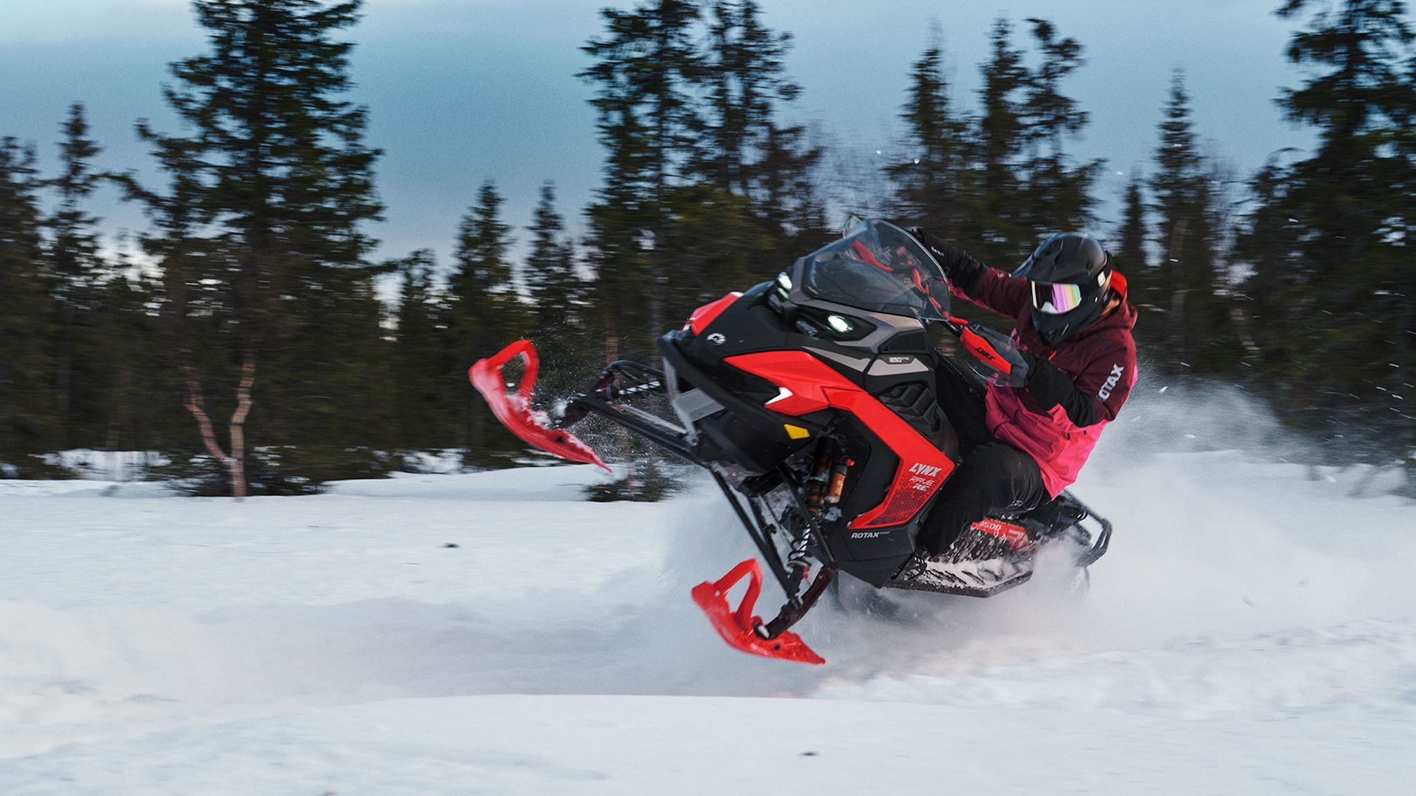 Une motoneige Lynx Xterrain RE 2025 faisant un virage rapide en sentier