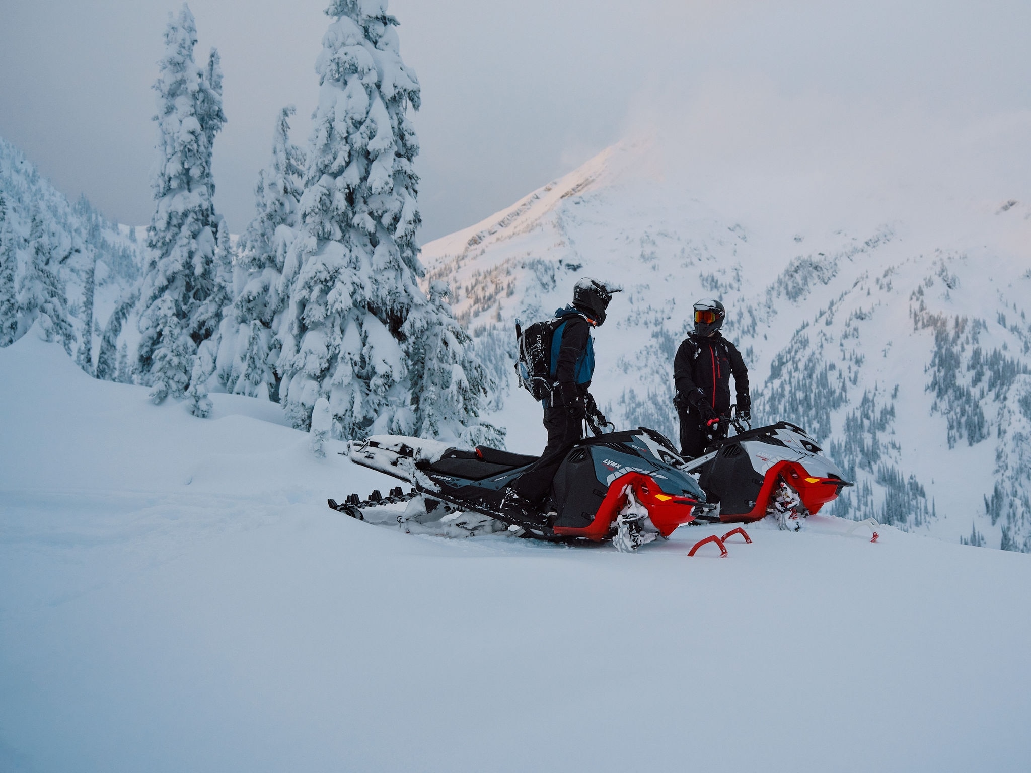 Kaksi moottorikelkkailijaa seisoo 2027 Lynx Shredder DS -moottorikelkkansa päällä