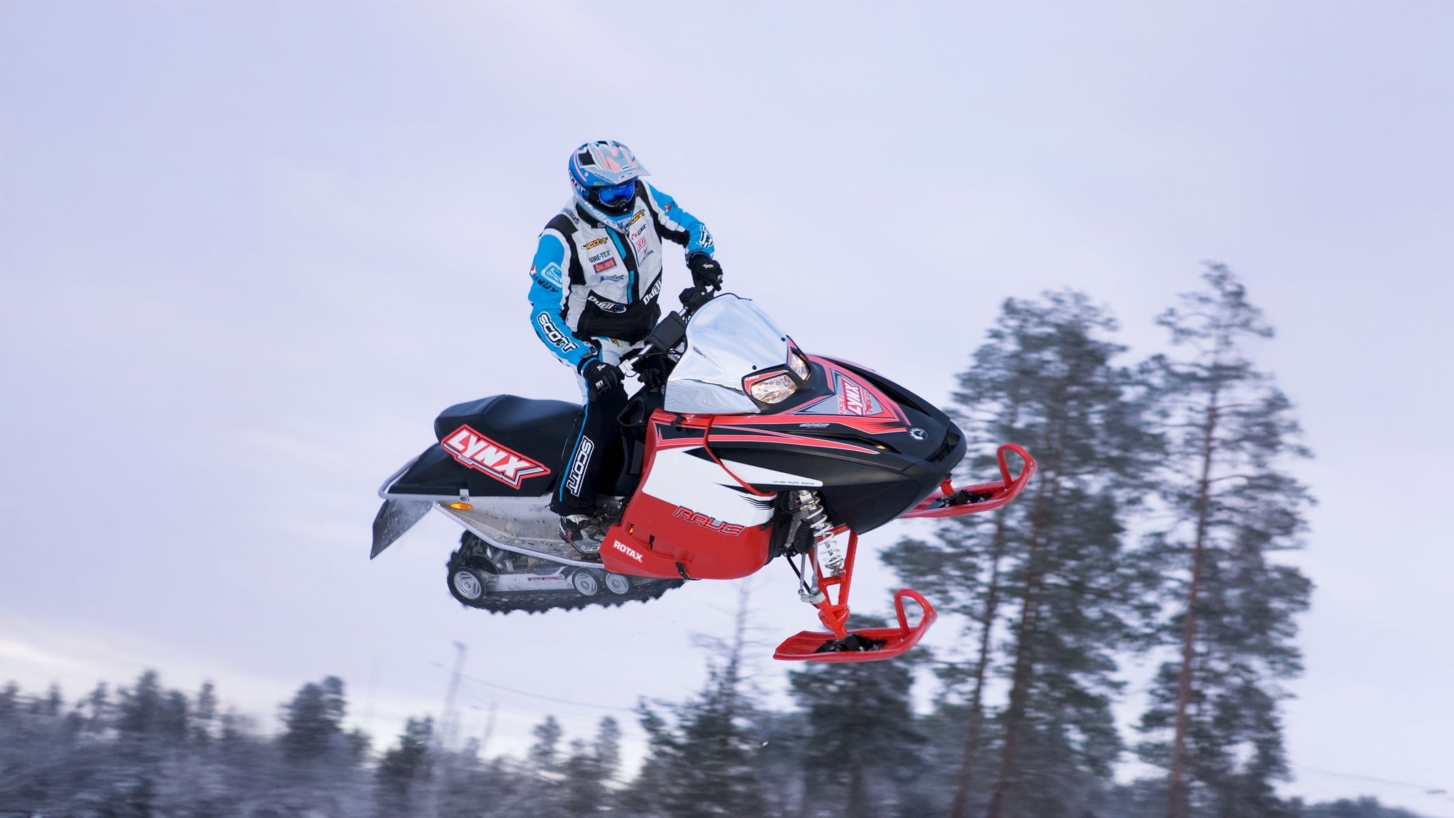 Ross Robinson kör en Lynx-snöskoter med en helikopter i baksätet