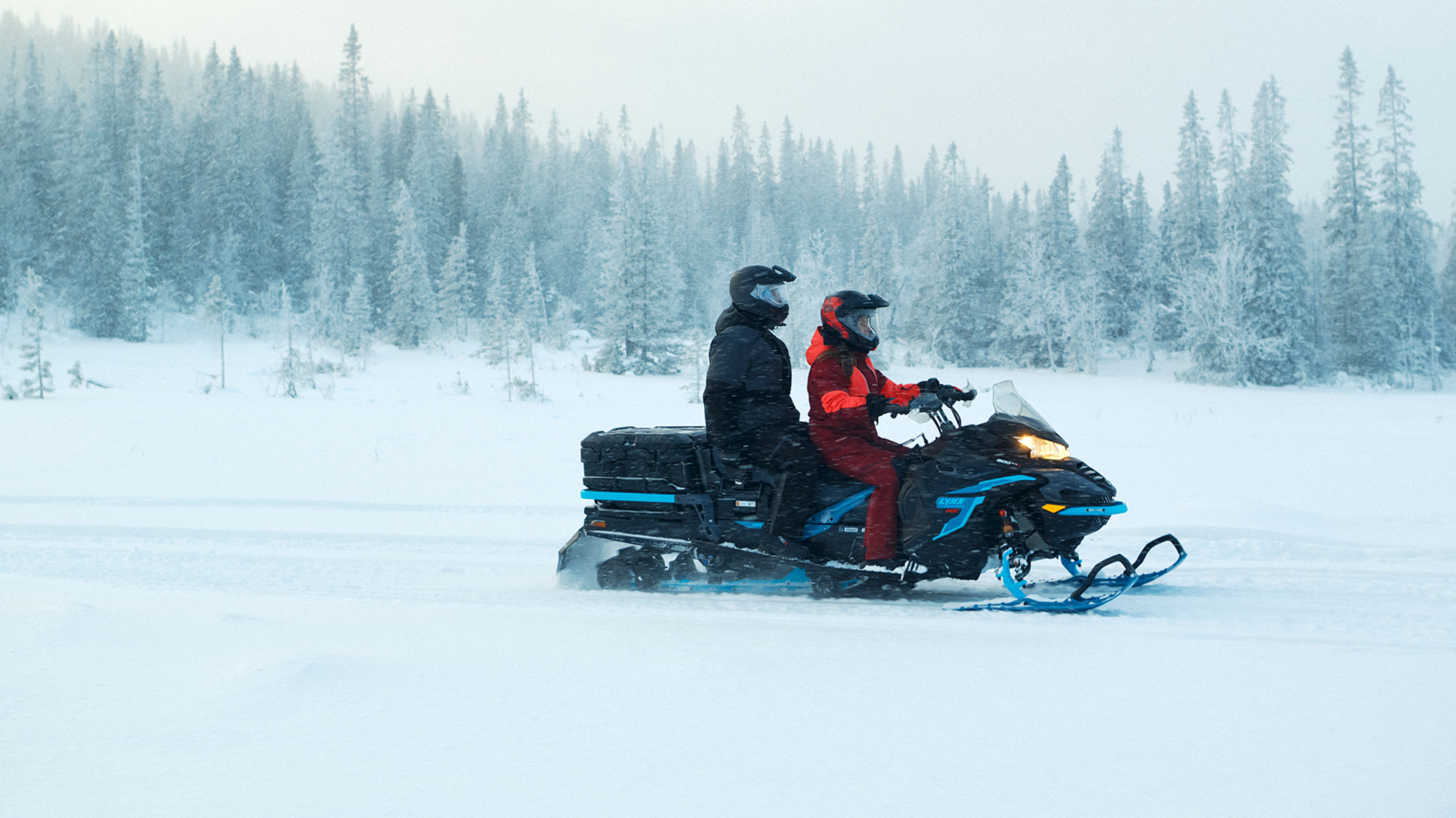 Couple riding 2up on trail with Lynx Commander RE snowmobile