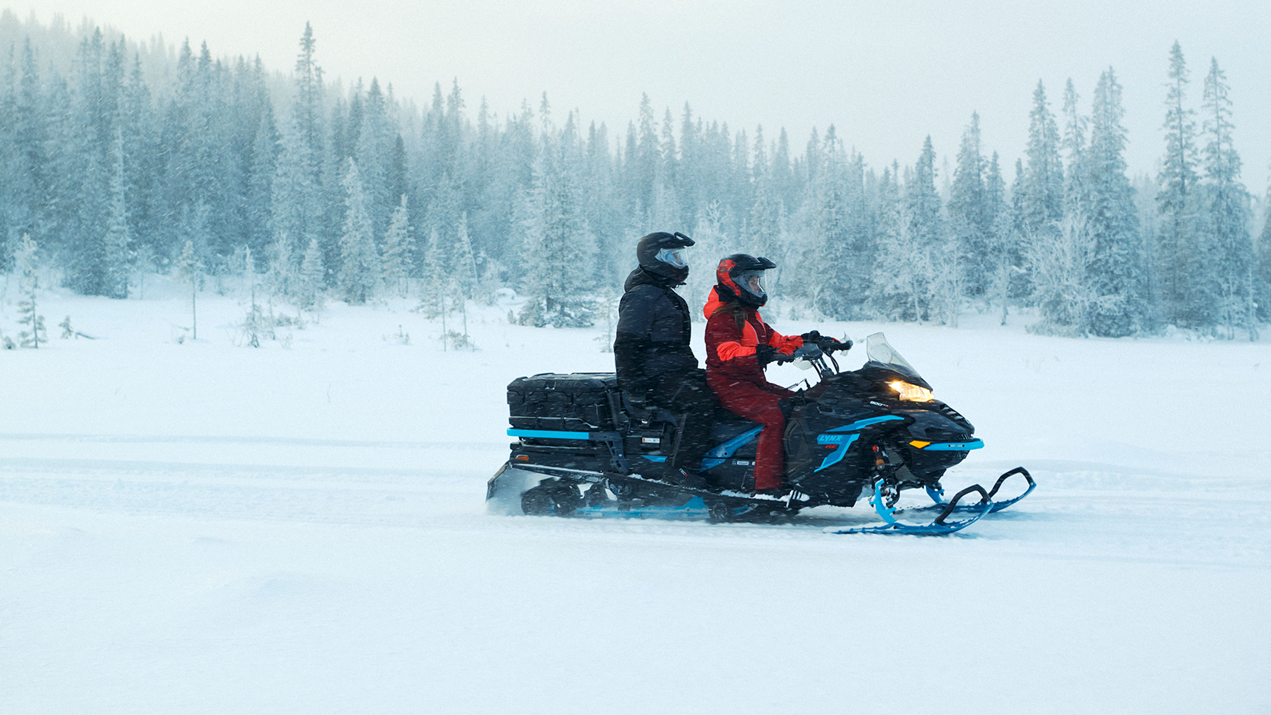 A couple on a trail with a Lynx Commander RE snowmobile