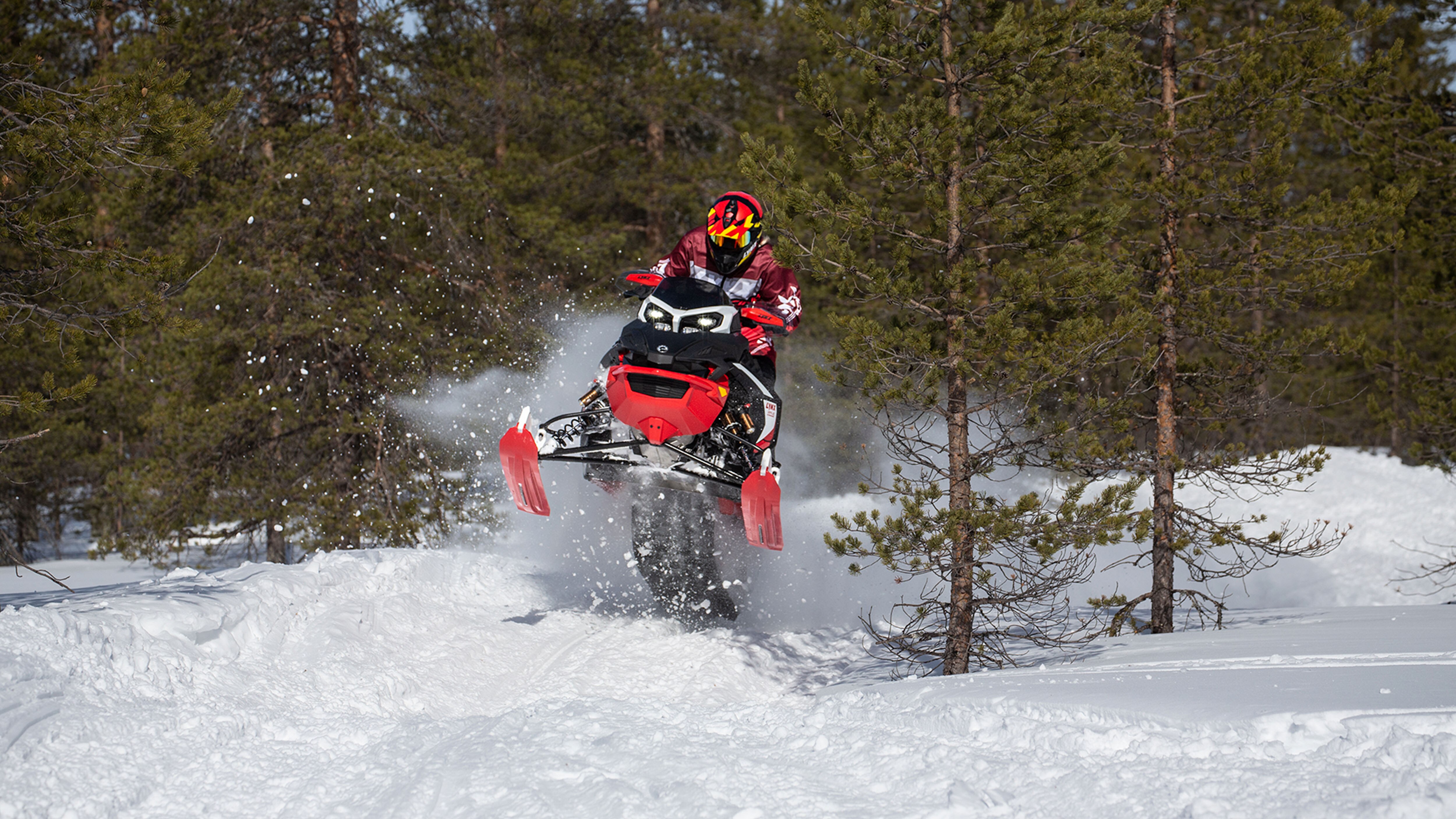 Rave RE snowmobile lifting skis from a bump on a trail