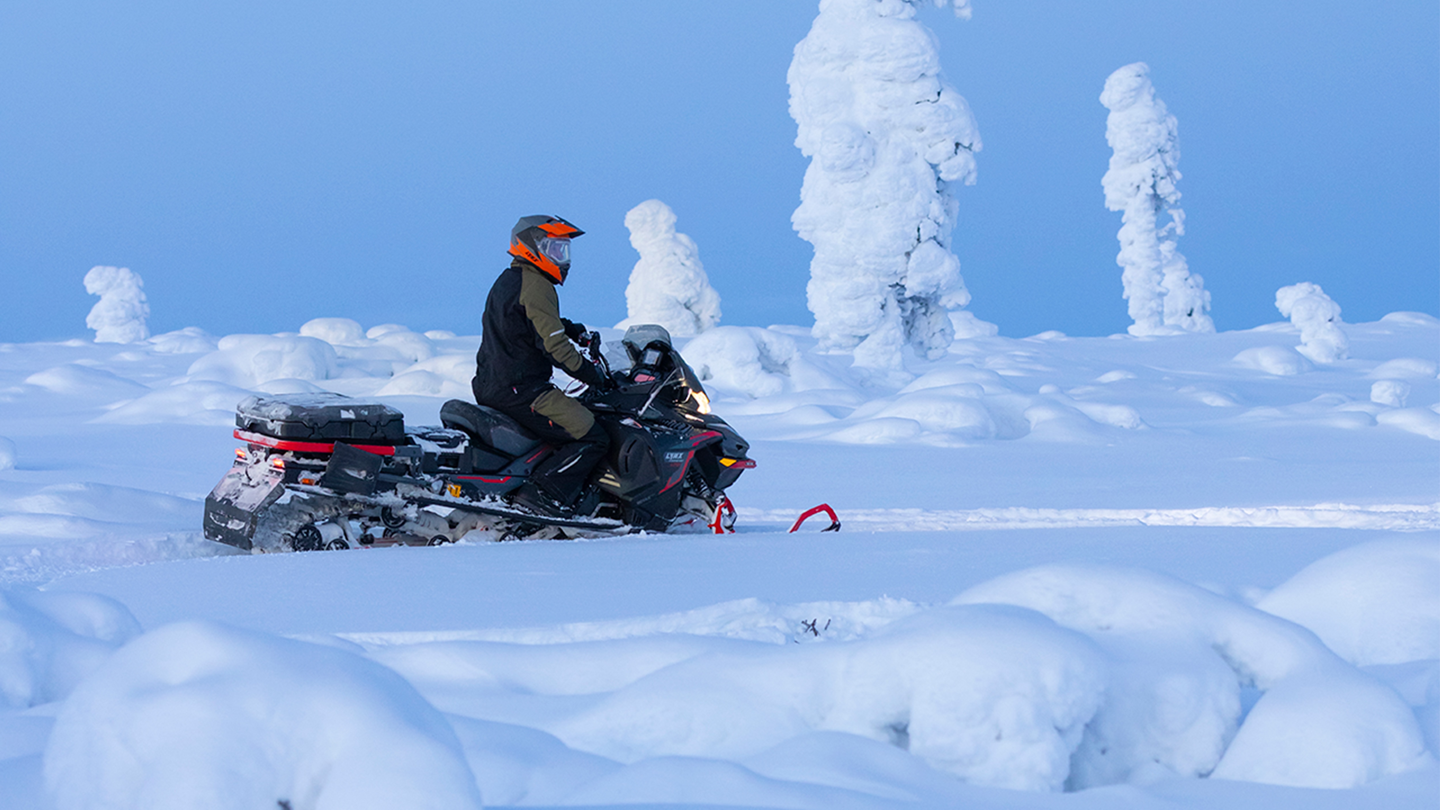 Rider on a Lynx Commander Limited snowmobile in the mountains