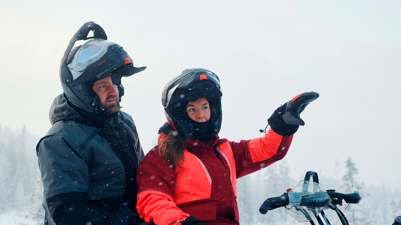 Couple wearing Lynx Stamina Arctic jackets on snowmobile