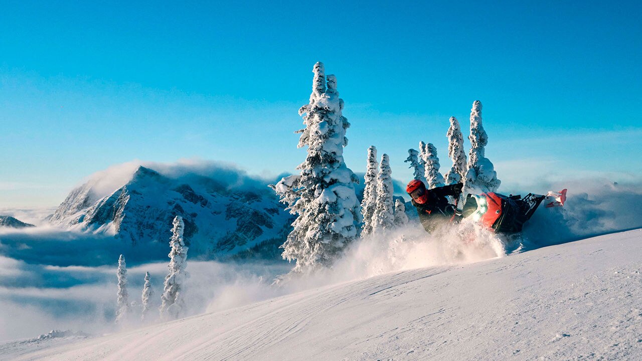 MAn carving through deep snow with a Lynx Shredder