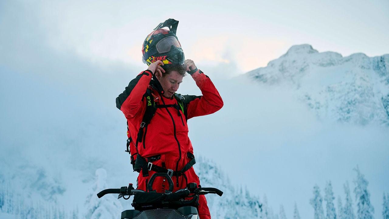 Man removing helmet from his head on the mountains after ride