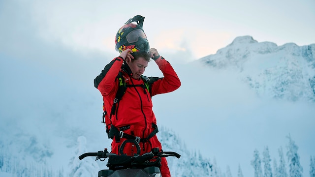 Man standing on his Lynx while putting on his helmet
