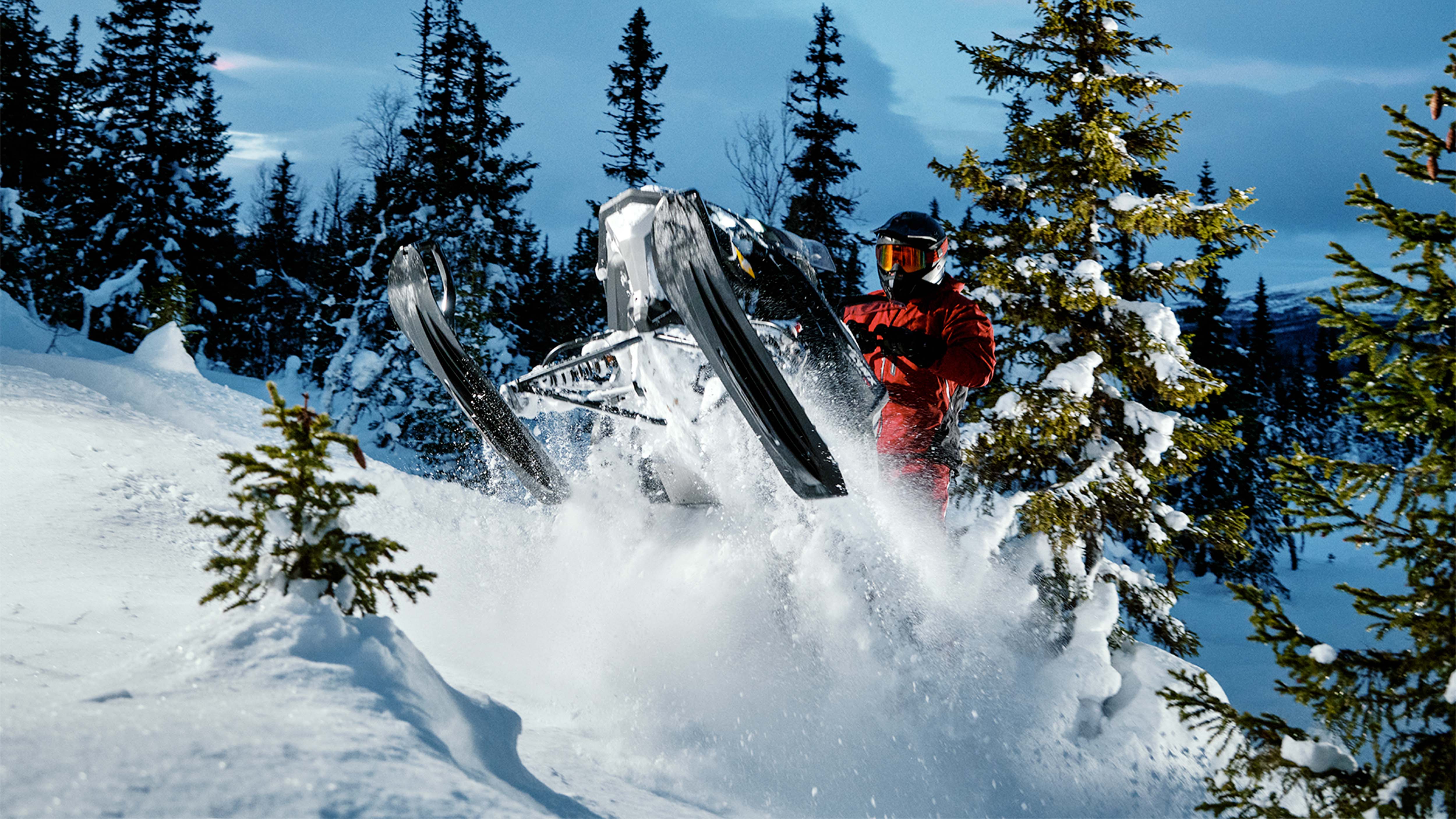 Lynx Brutal RE 2025 snowmobile wheelying uphill at the dark forest