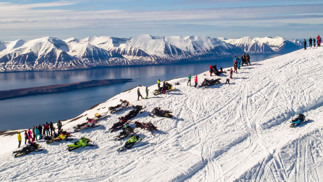 Motoneigistes au sommet d'une montagne en Islande.