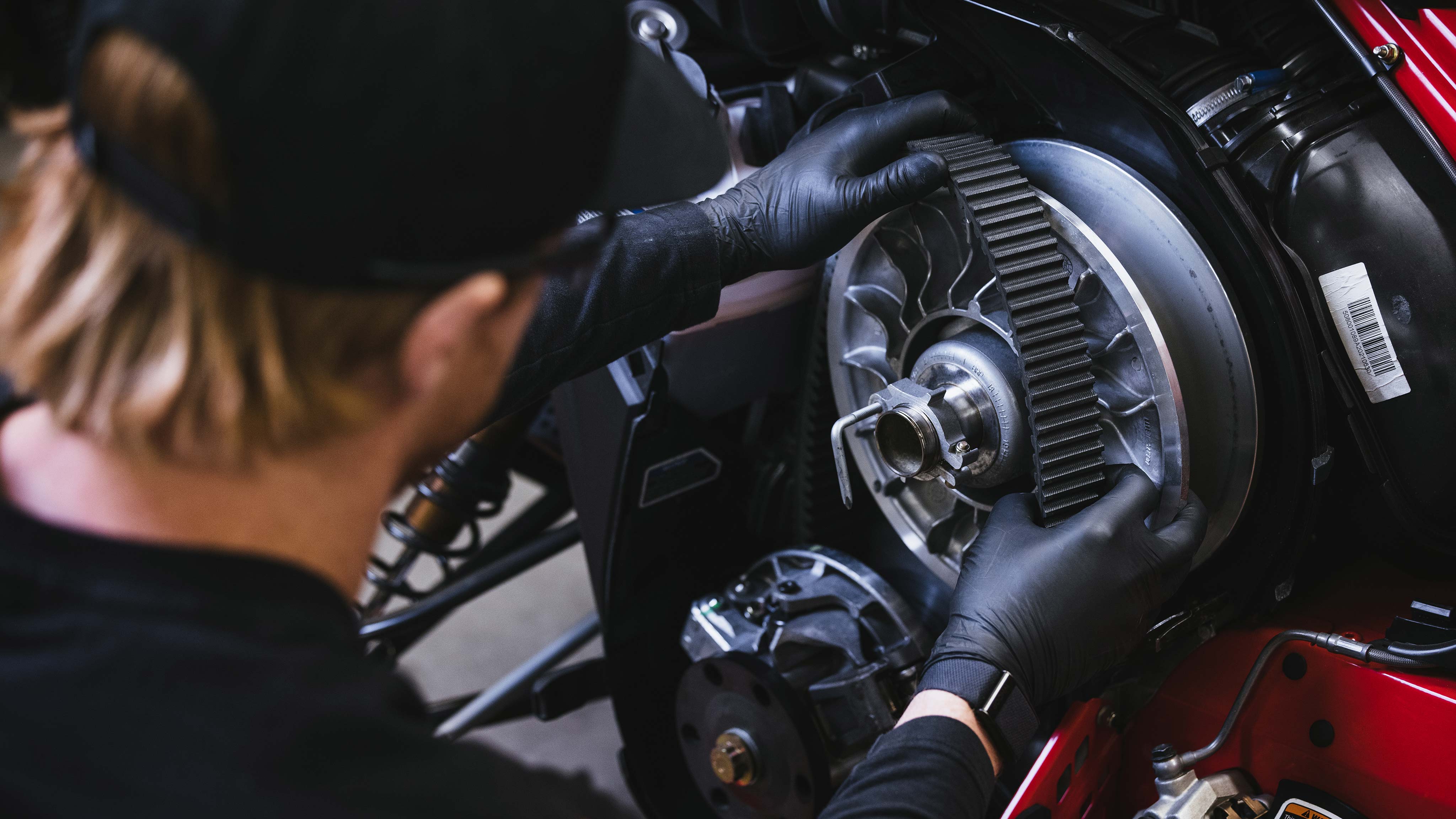 Man changing the CVT belt on his Lynx snowmobile