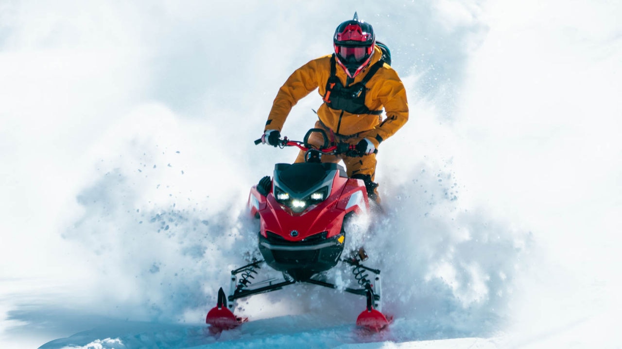 Ross Robinson riding a Lynx snowmobile in deep snow