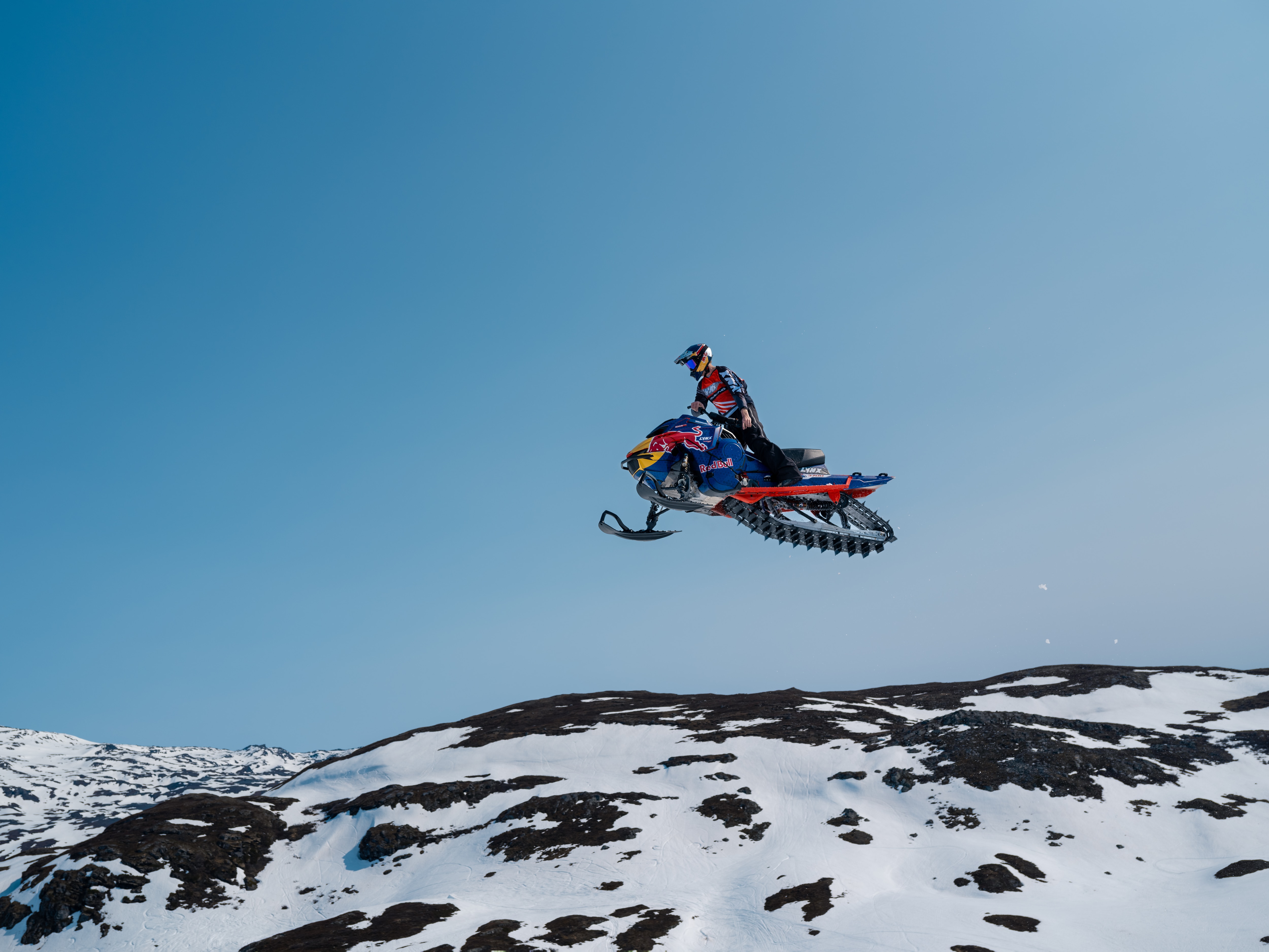 Lynx ambassador standing on his 2025 Lynx Shredder snowmobile.