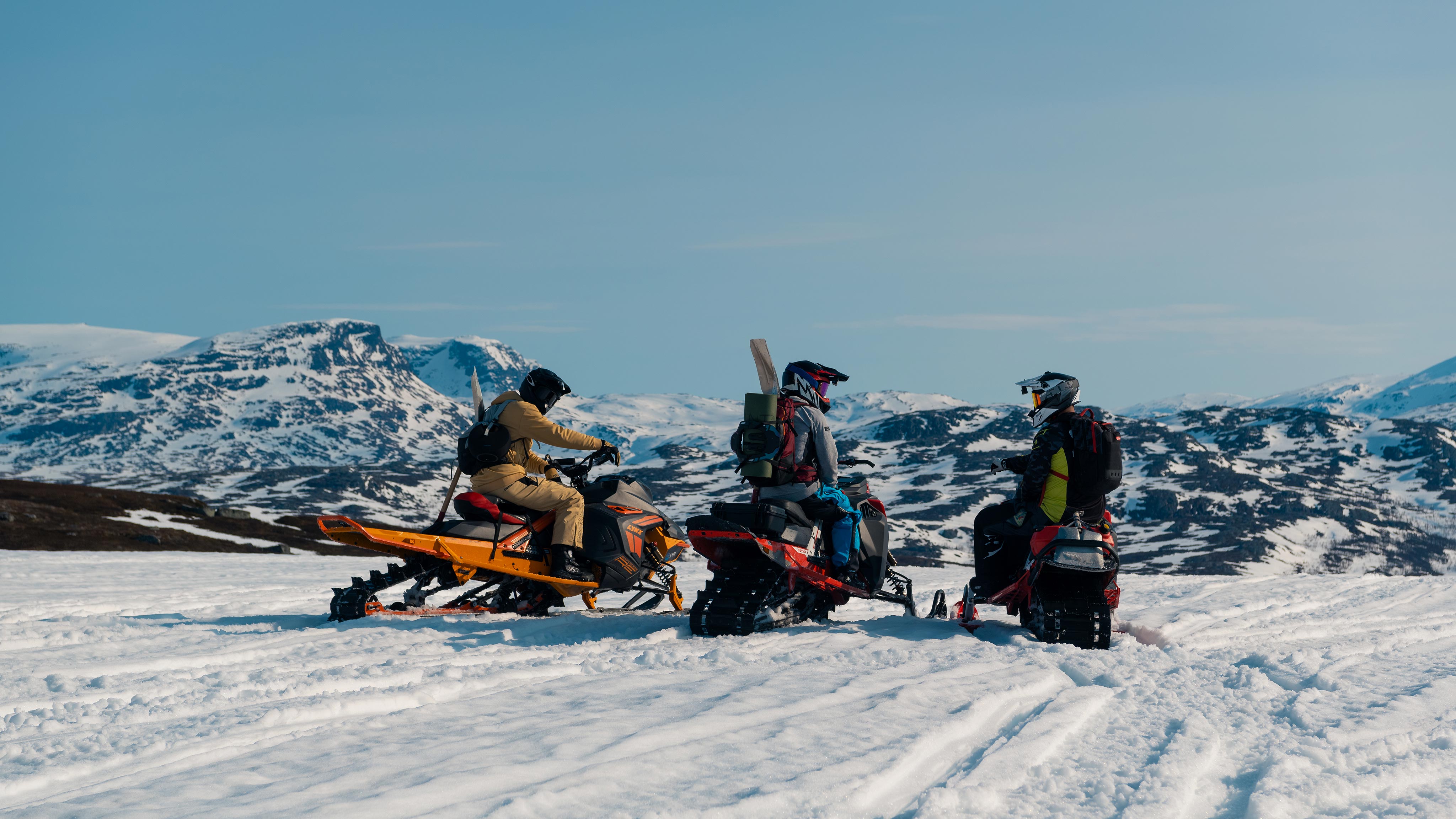 Tre Lynx-førere på toppen av et fjell