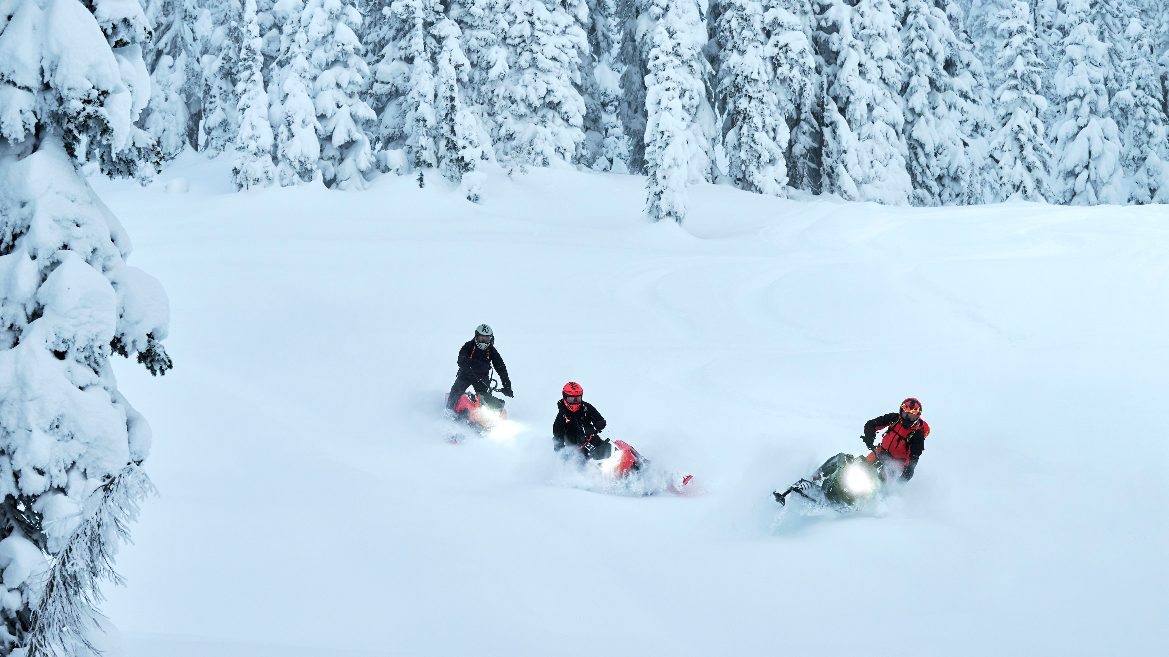 Three riders on Lynx Shredder snowmobiles