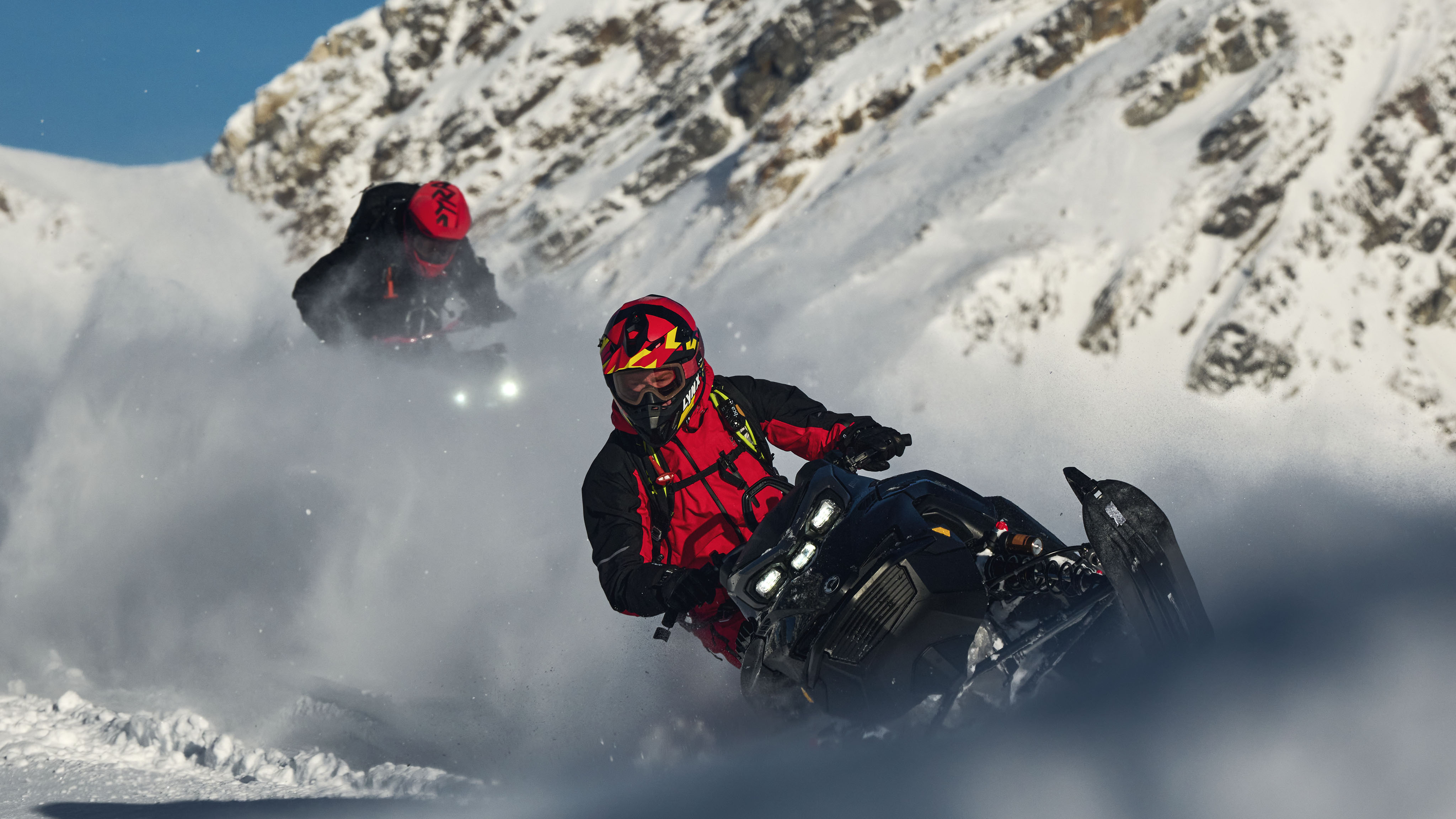 Two men riding Lynx Shredder snowmobiles in deep snow