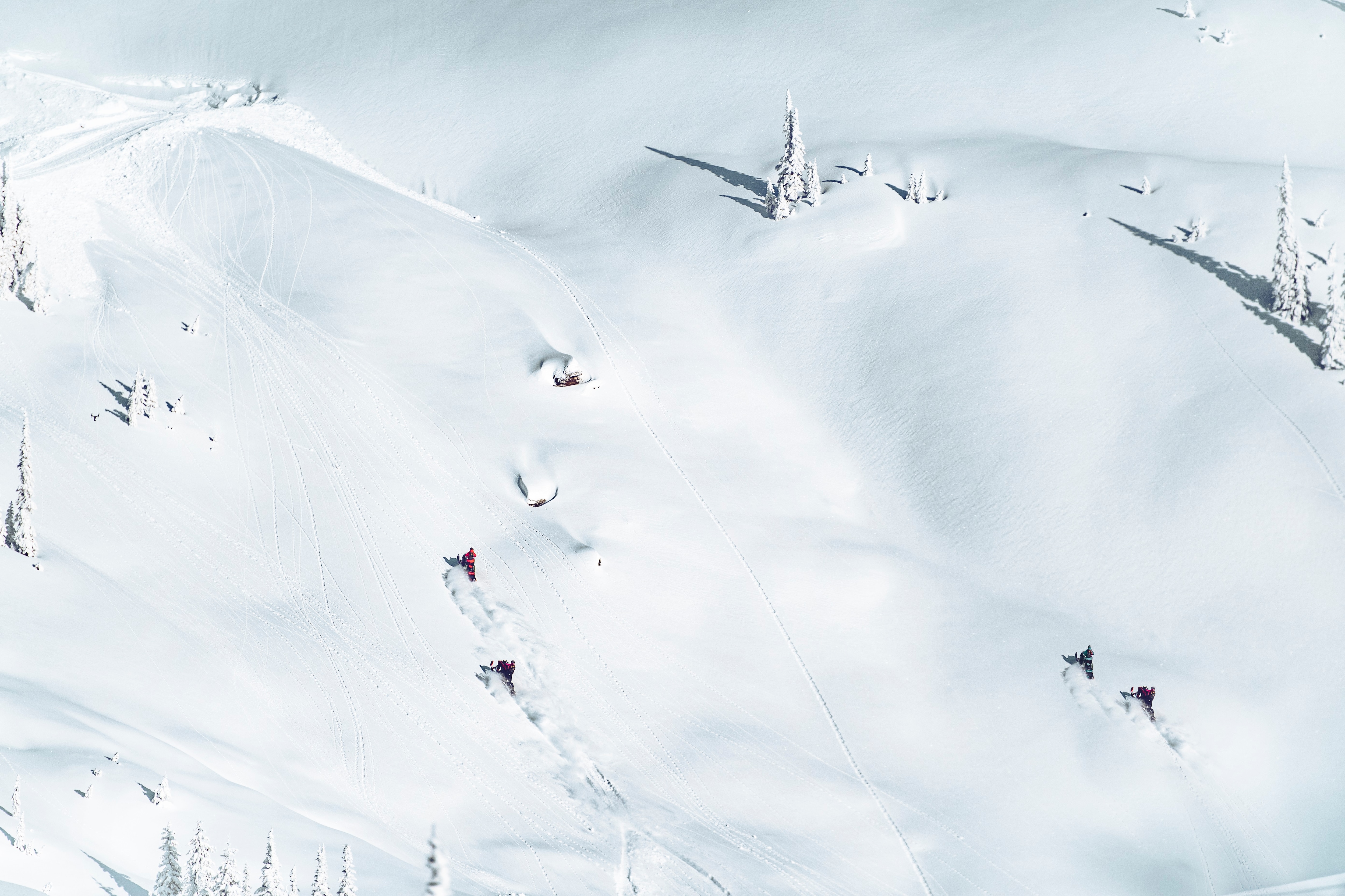 Two snowmobile riders riding their Lynx on a snowy mountain