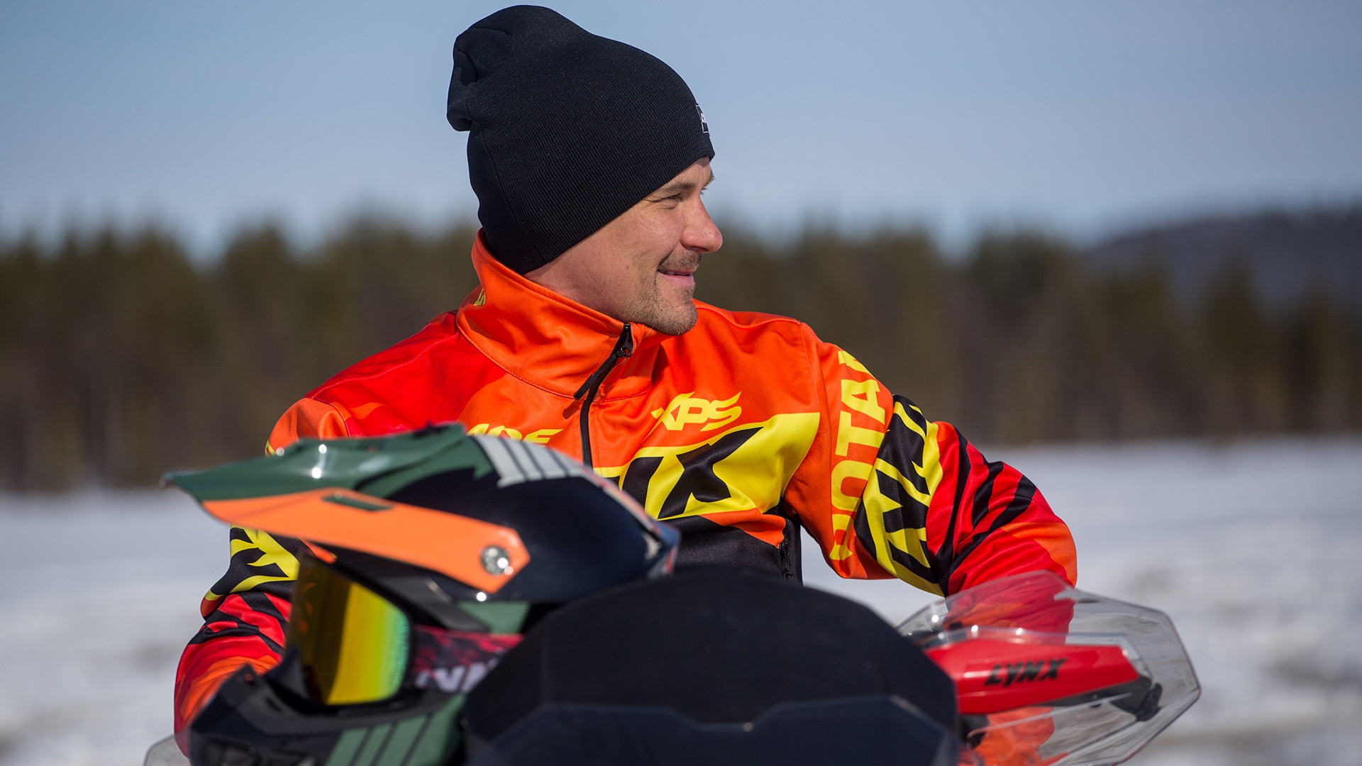 A race driver Toni Vilander sits on a Lynx snowmobile.