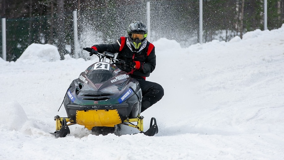 Vintage kilpa moottorikelkka Lynx ajaa kurvia suomalainen naiskuljettaja