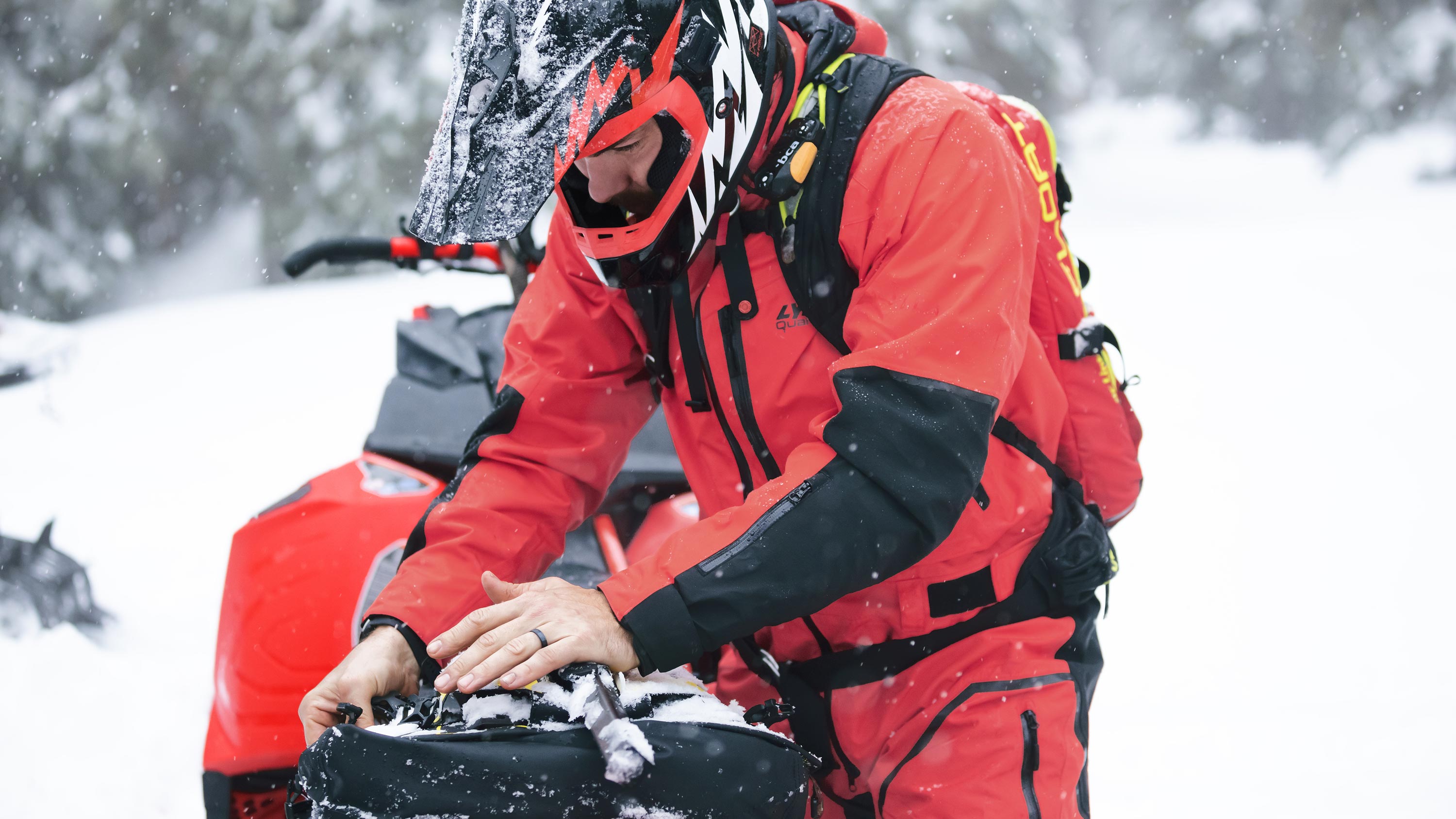 Lynx snöskoterförare som stänger en LinQ packväska i terräng