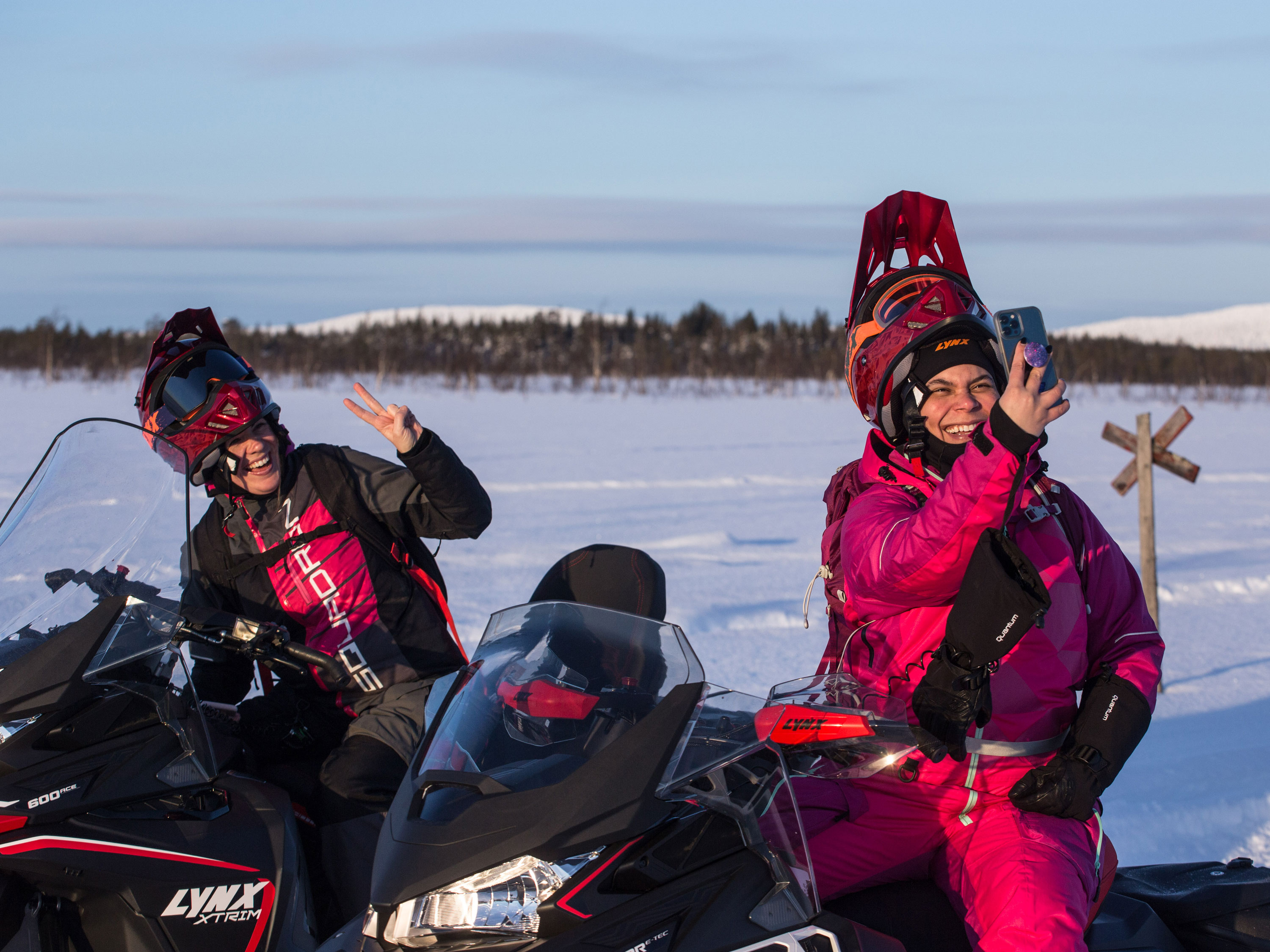 Minttu and Inari taking a picture on Lynx snowmobile