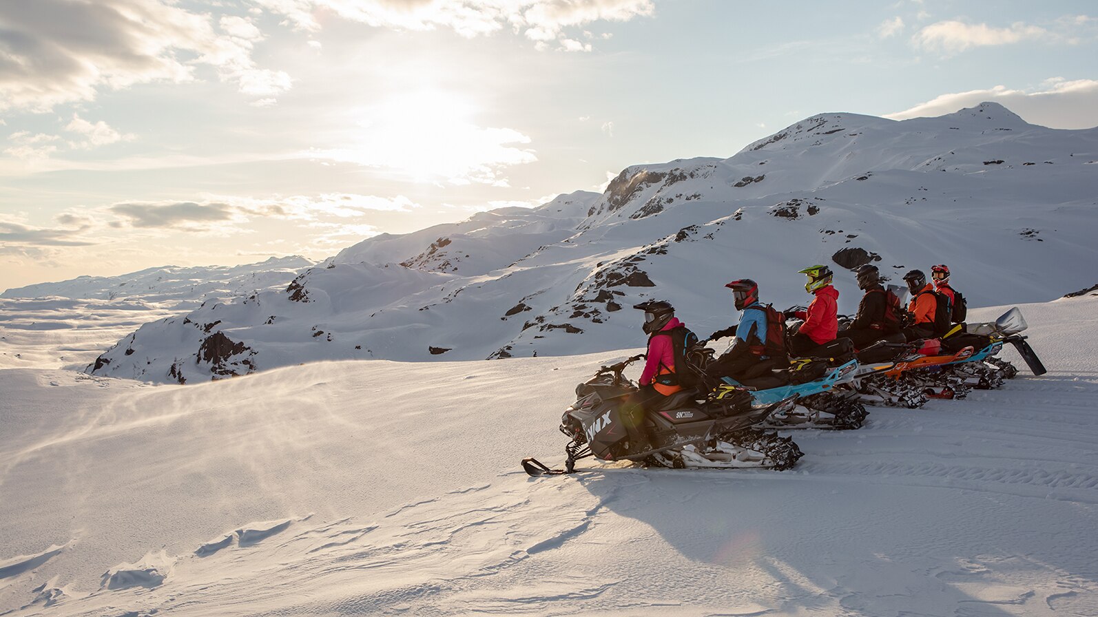 Lynx snowmobiles in a row at Riksgränsen sunset