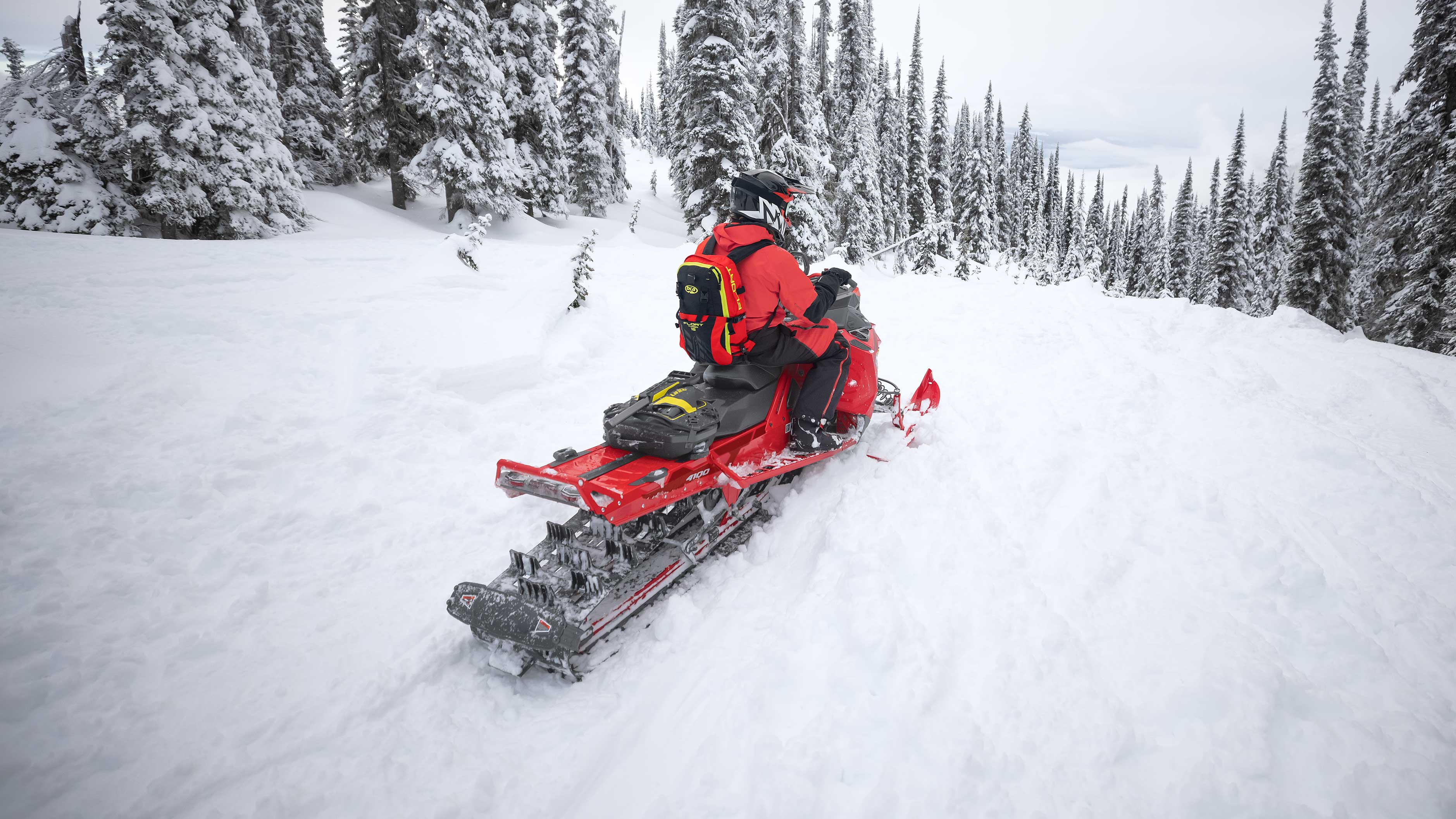 Man well equiped on a red Boondocker in a snowy forest