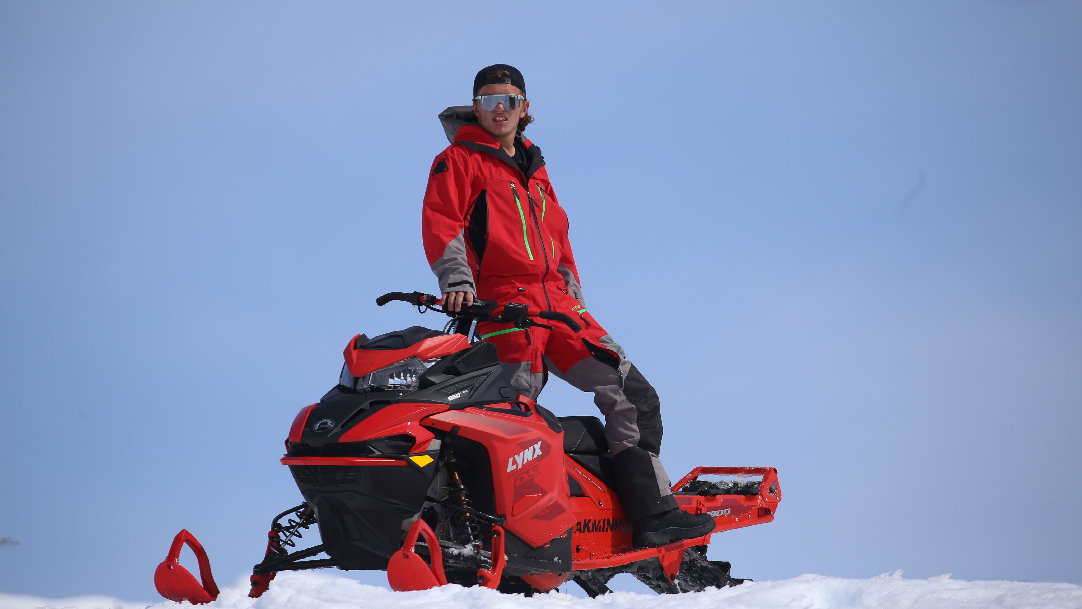 Warren Gage standing on a Lynx snowmobile