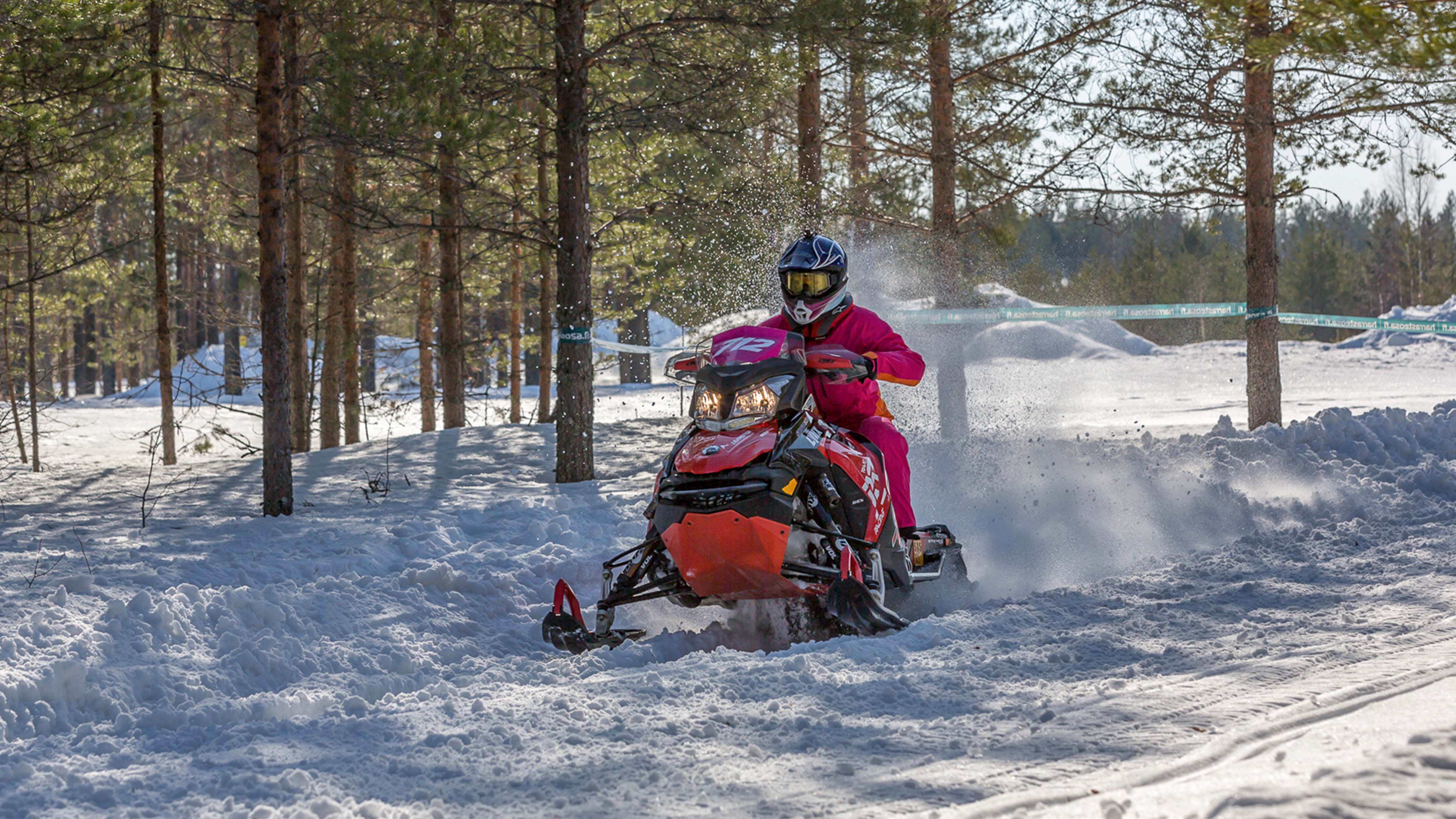 Une femme conduit une motoneige dans une course d'endurance.