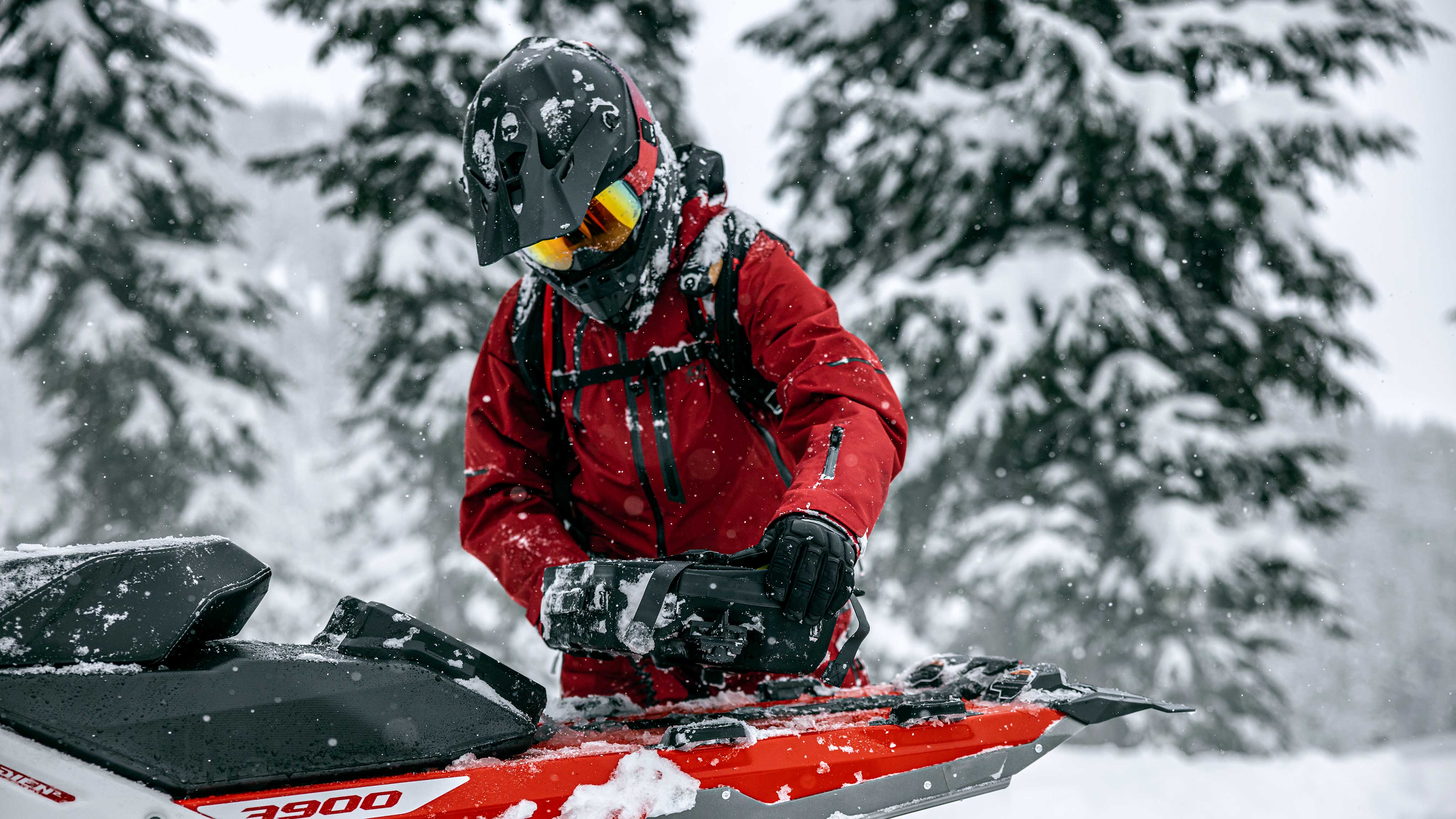 Rider installing a large LinQ tunnel bag on their 2023 Lynx snowmobile