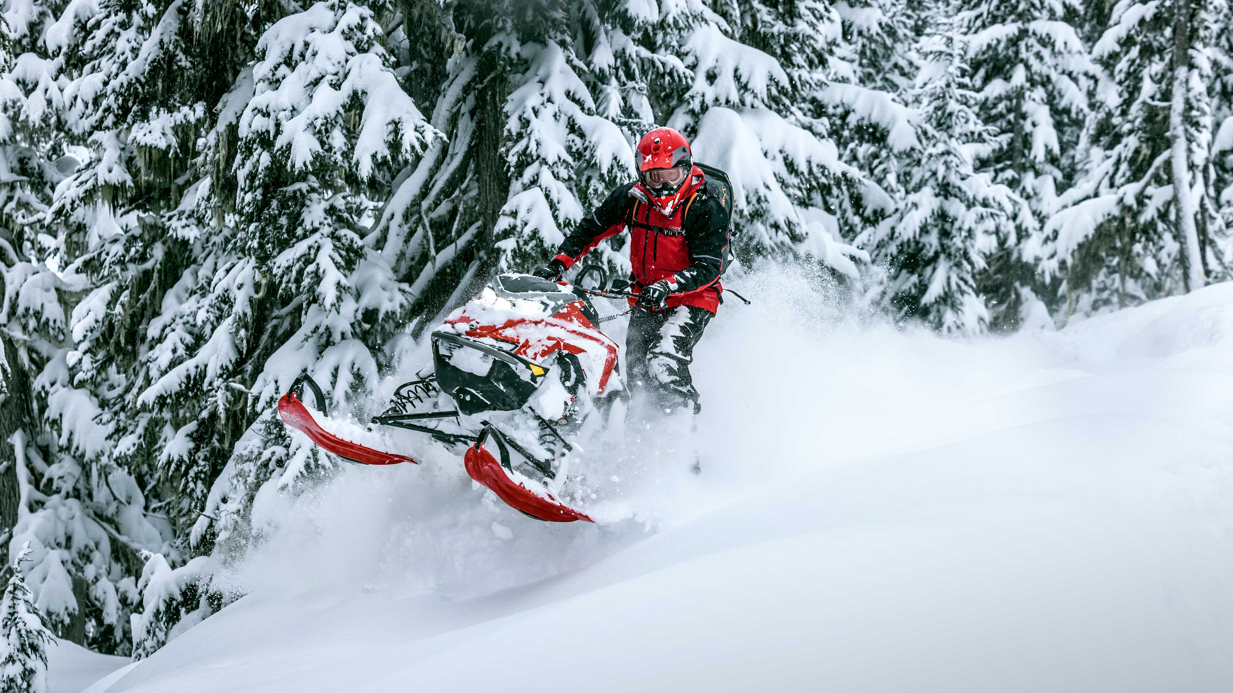 Rider standing on their Lynx snowmobile