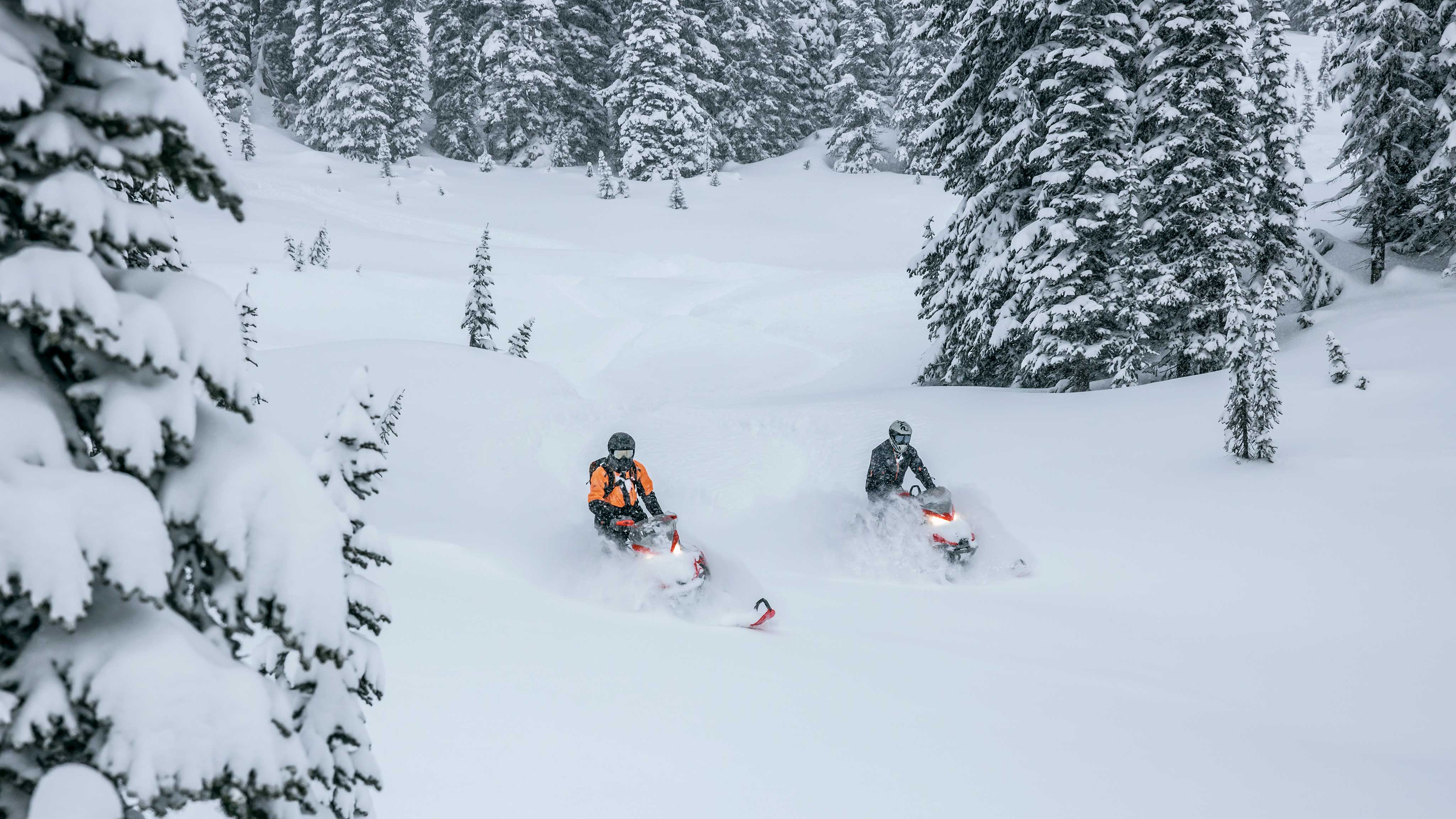 Two Lynx riders on their snowmobile in deep snow