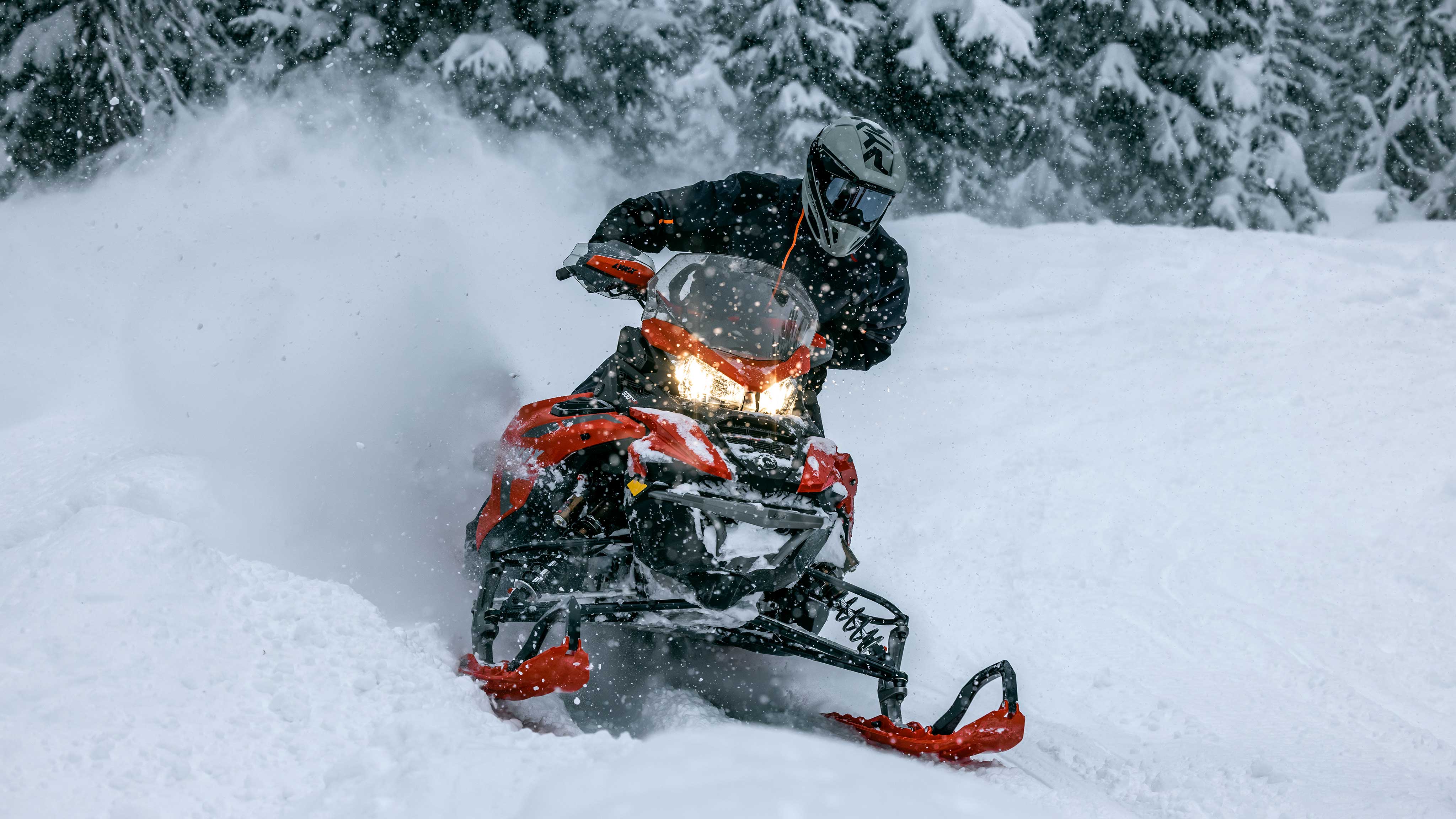 Rider blowing some snow on their Lynx snowmobile