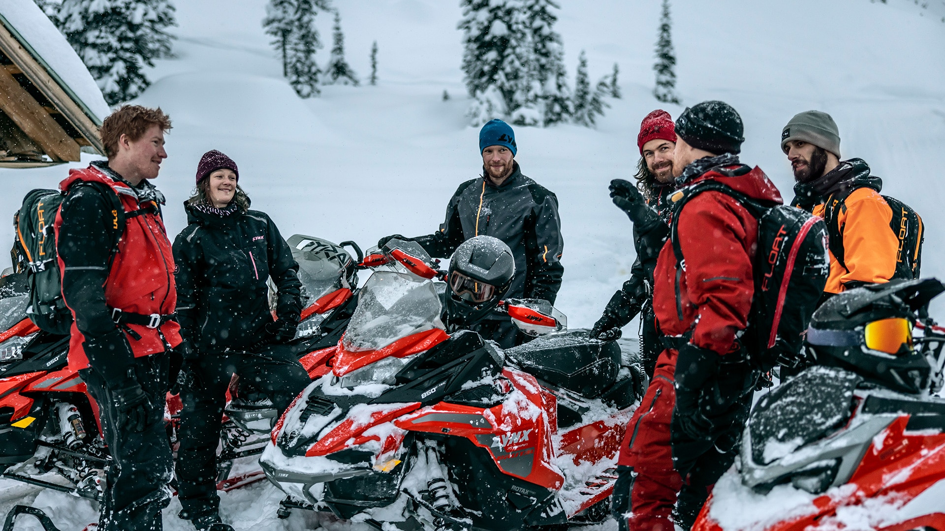Group of riders catching up around their Lynx snowmobiles