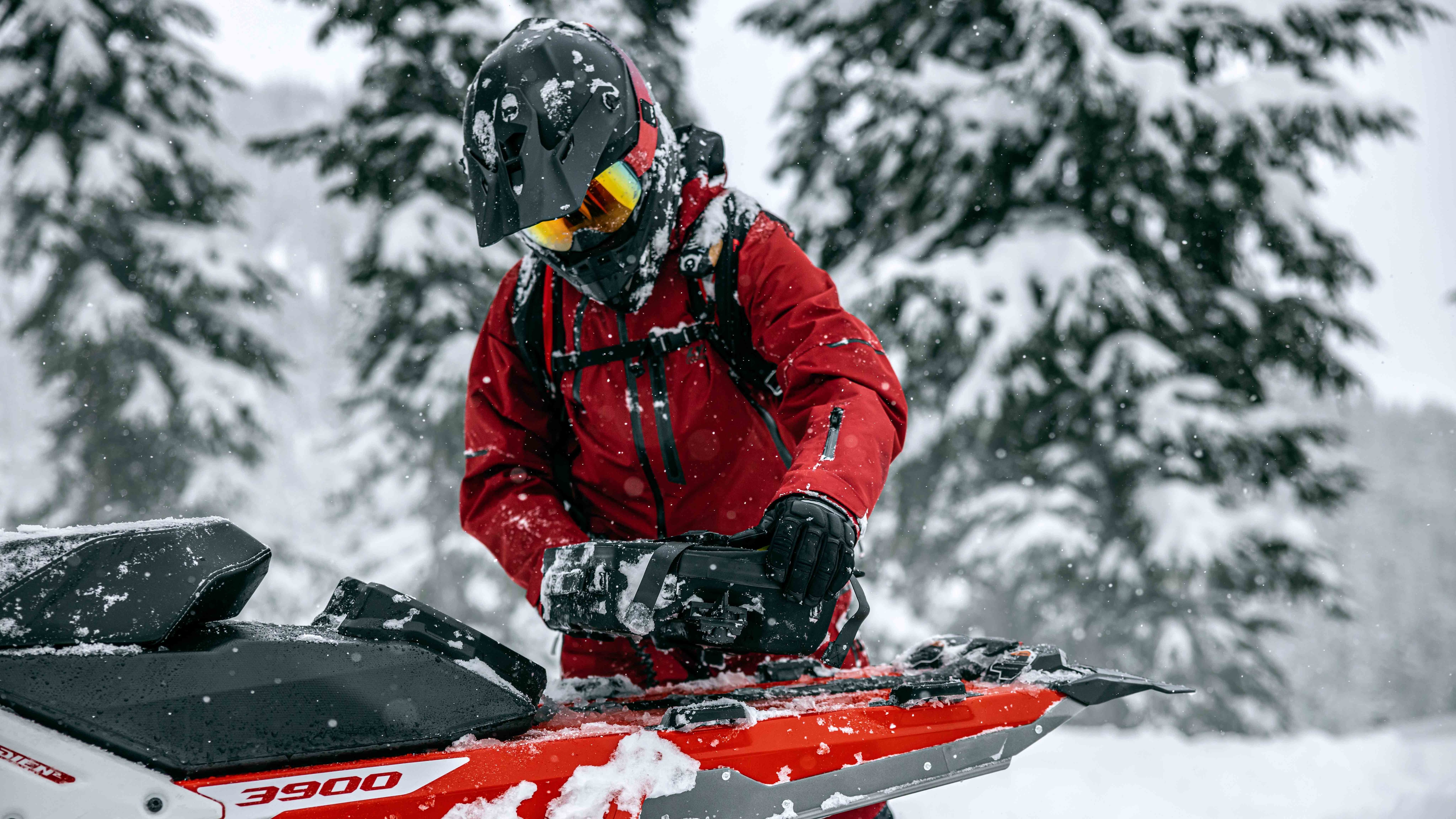 Rider attaching a LinQ bag to Lynx snowmobile