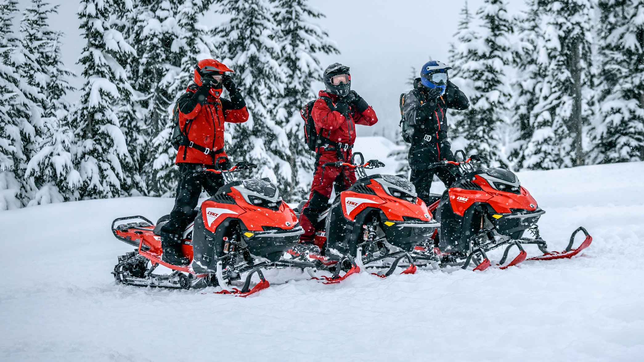 Kolme Lynx Shredderin ratsastajaa valmistautumassa kyytiin