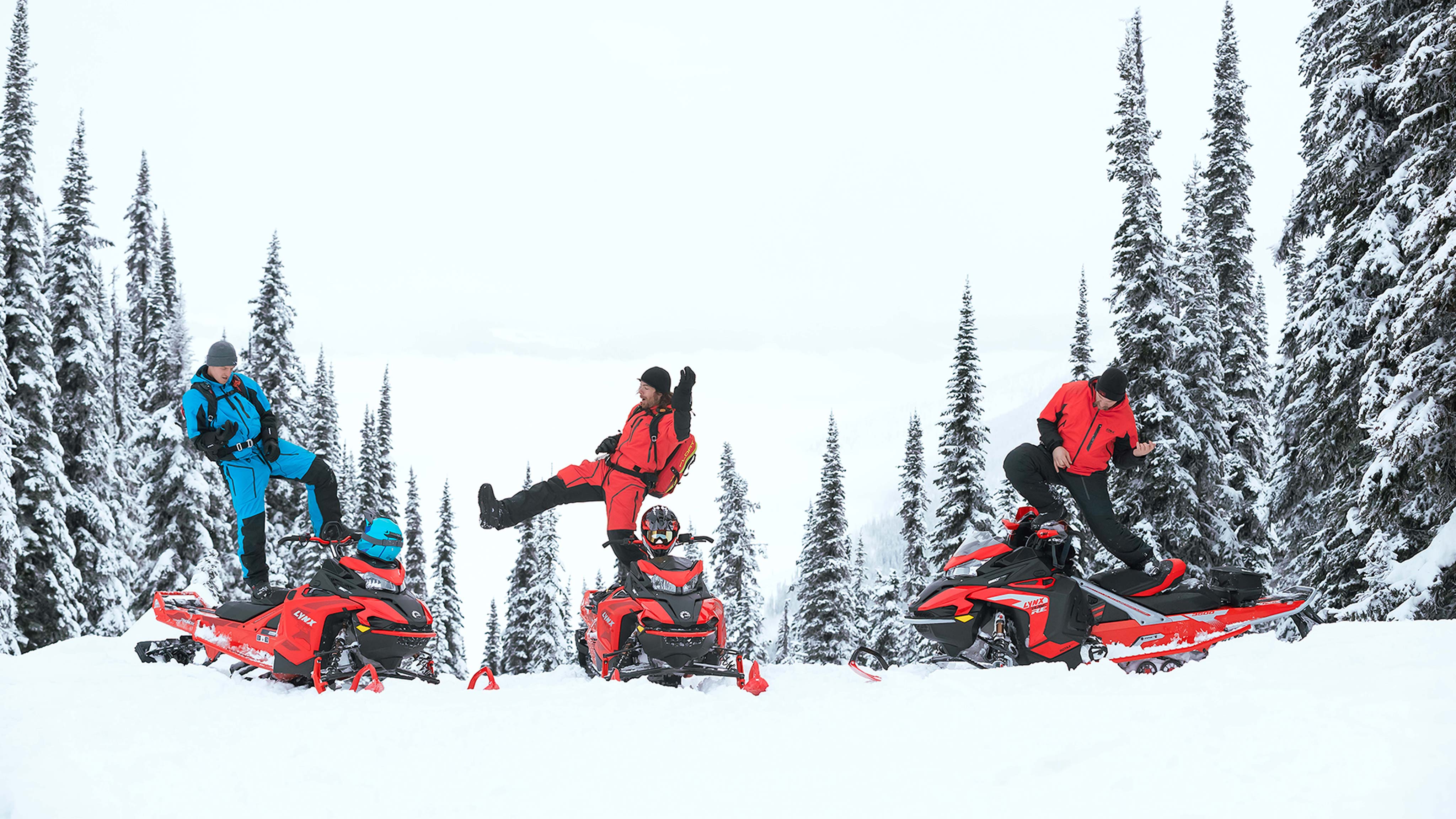 Trois hommes jouant de l'air guitar sur une motoneige Lynx BoonDocker à la montagne.