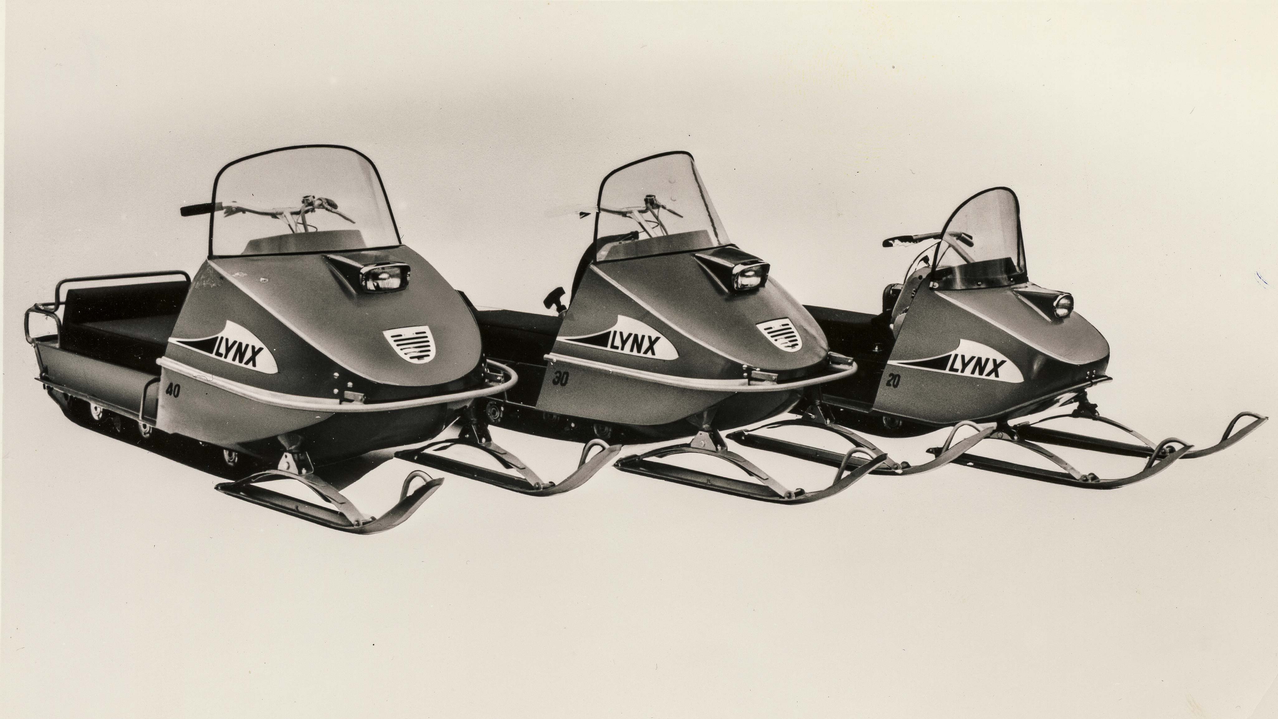 Three old Lynx snowmobiles in a row in studio
