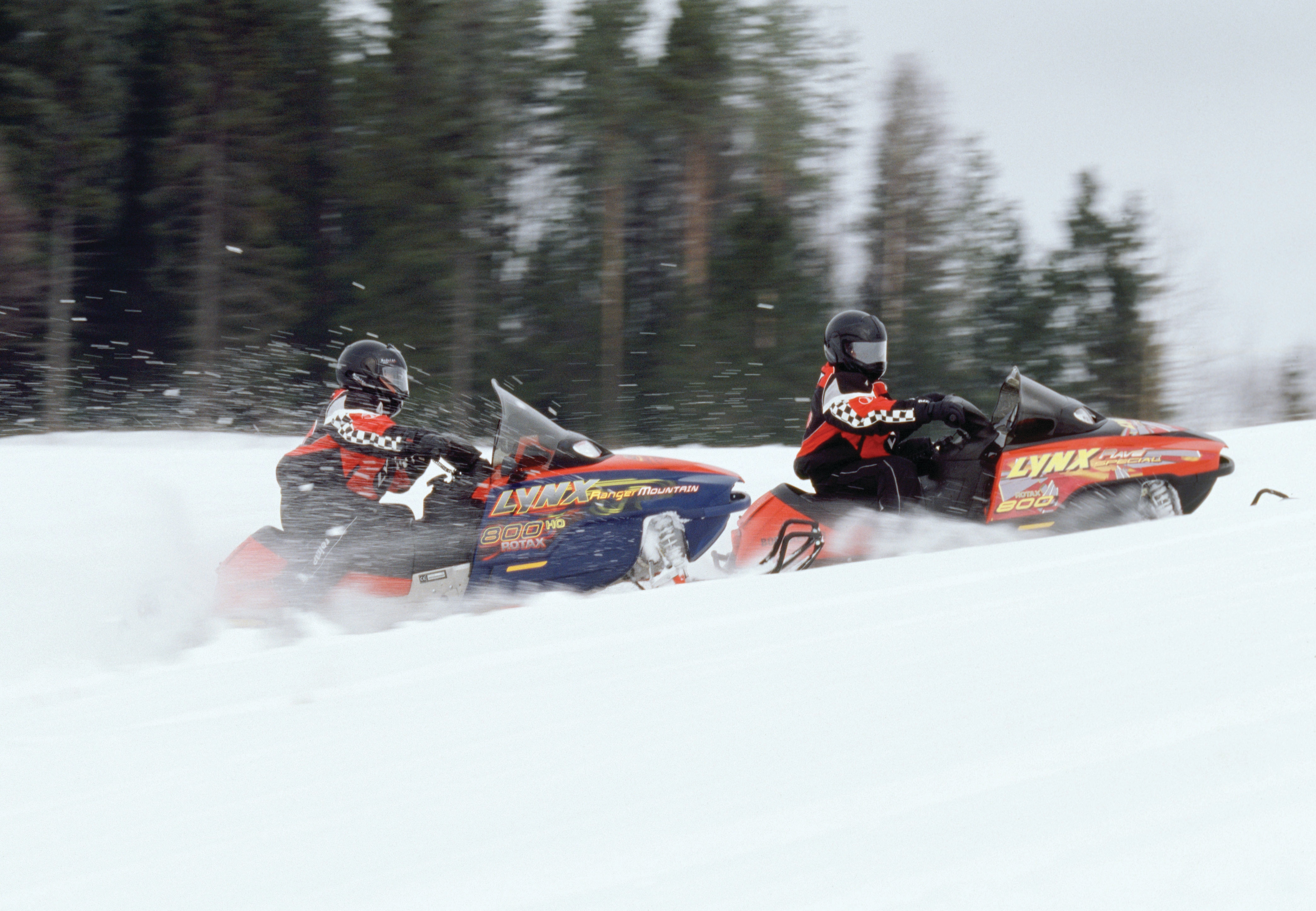 Lynx Rave and Ranger Mountain snowmobiles accelerating uphill