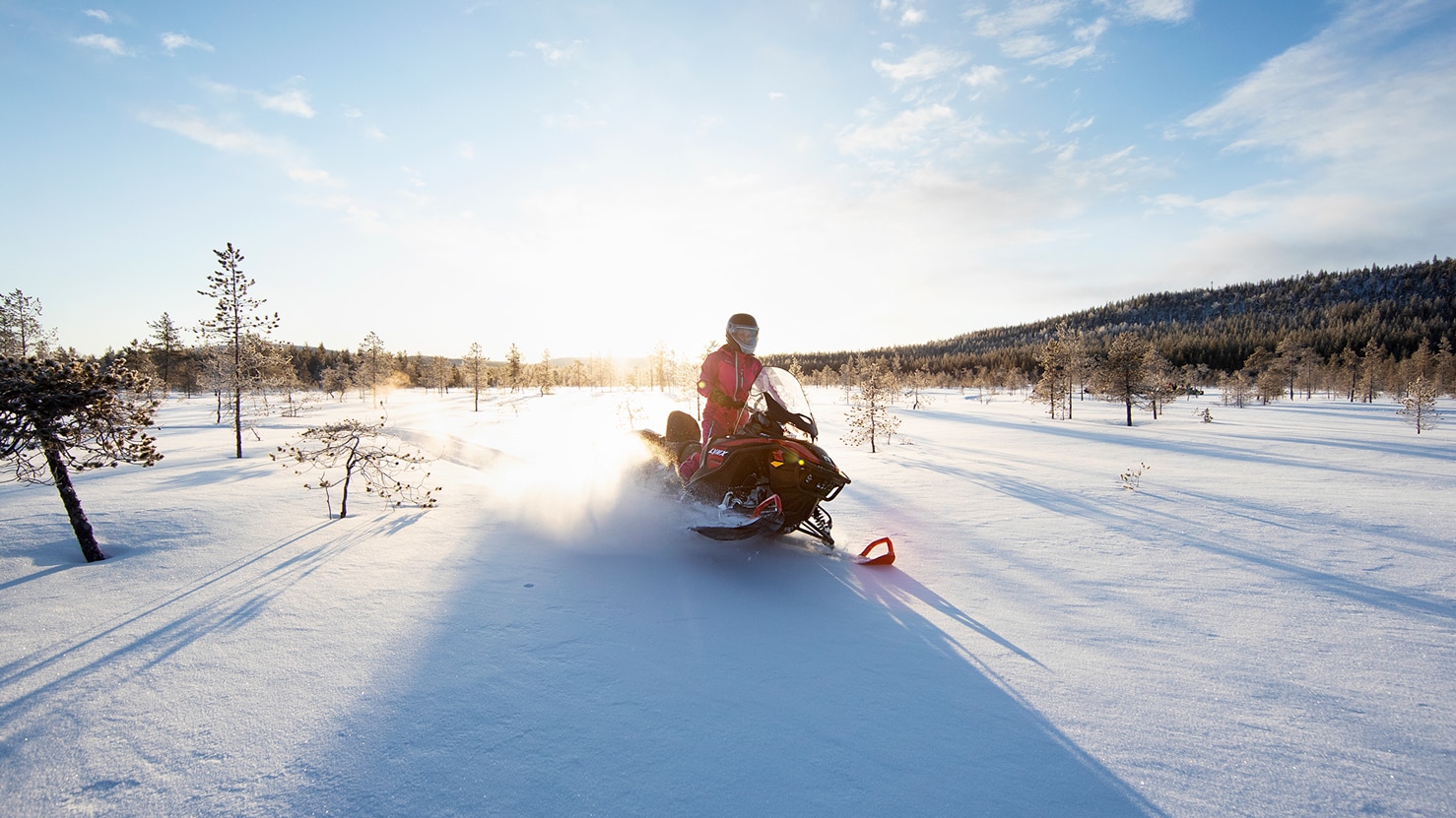 59 Ranger snowmobile turns in powder snow on a open meadow