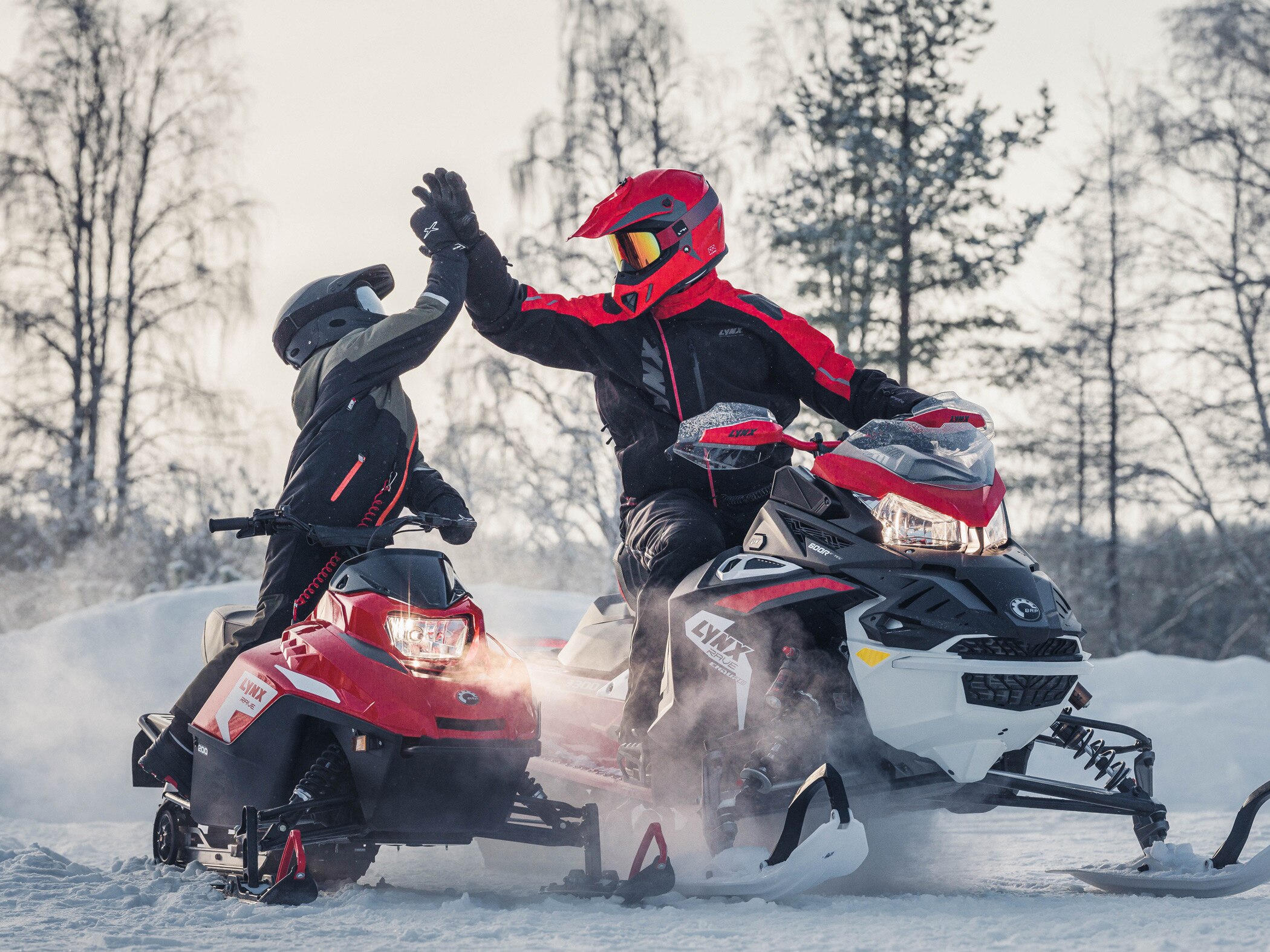 Mann og barn har det moro på Lynx snøscootere