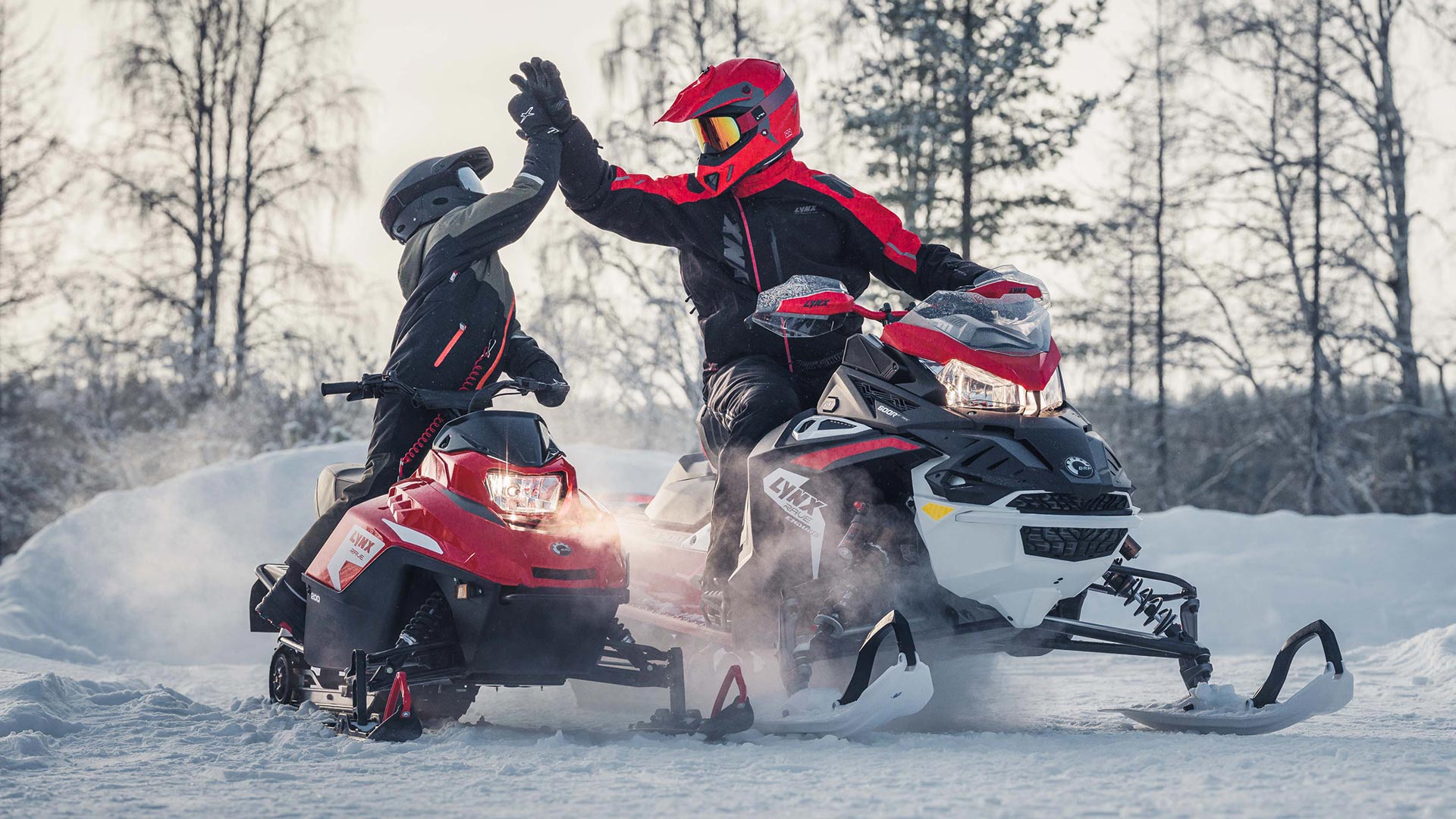 Child and parent driving their Lynx-snowmobiles