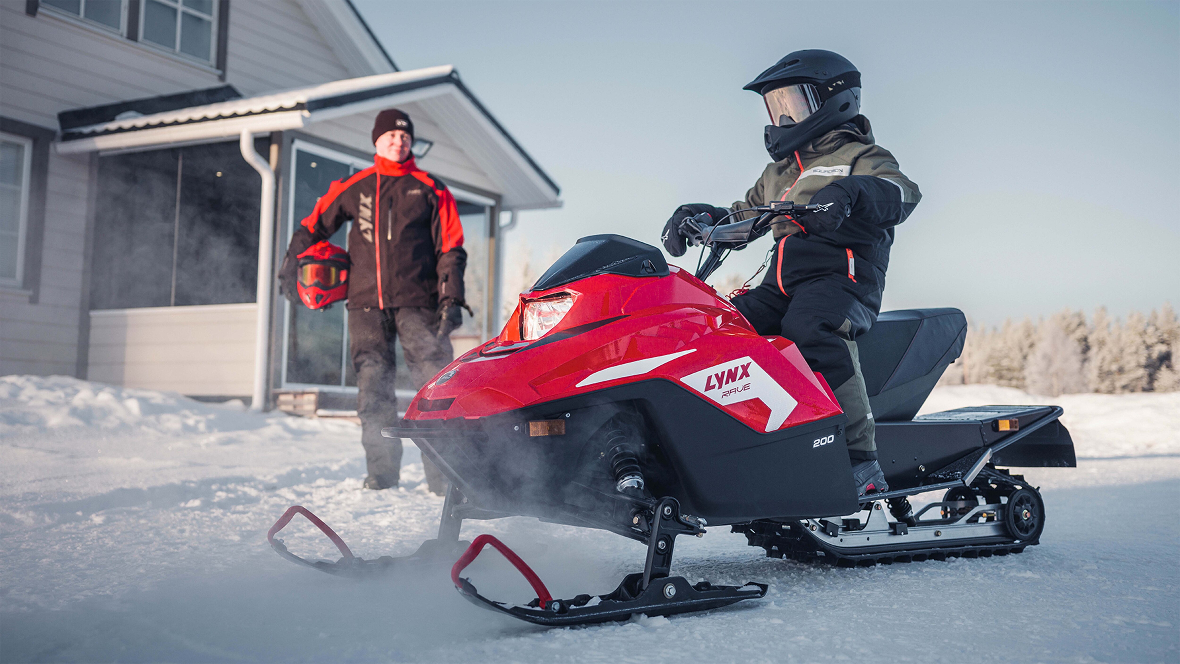 Lynx Rave 200 snowmobile with a kid on the yard