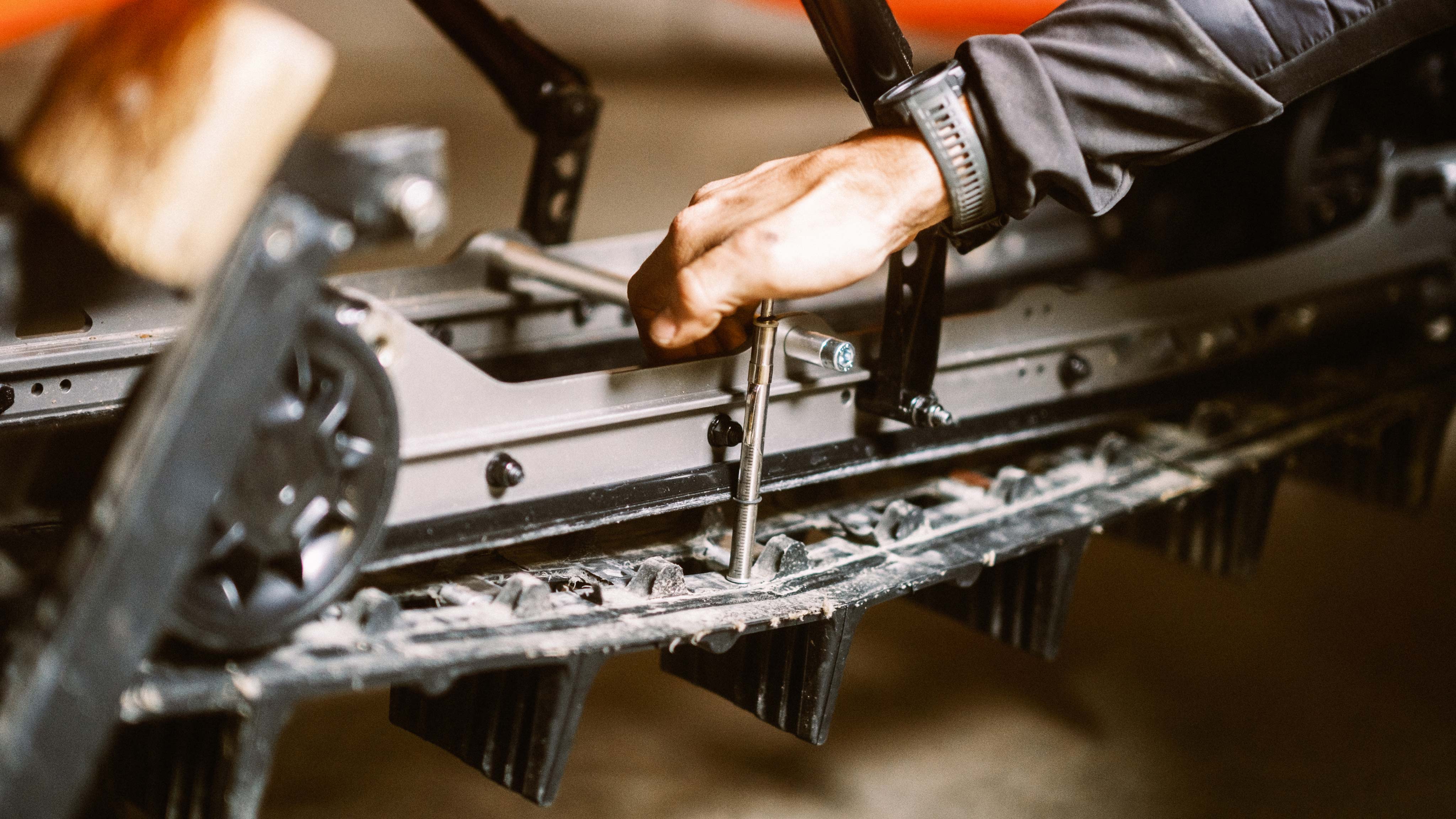 Jason Ribi adjusting the tension of his Lynx snowmobile track