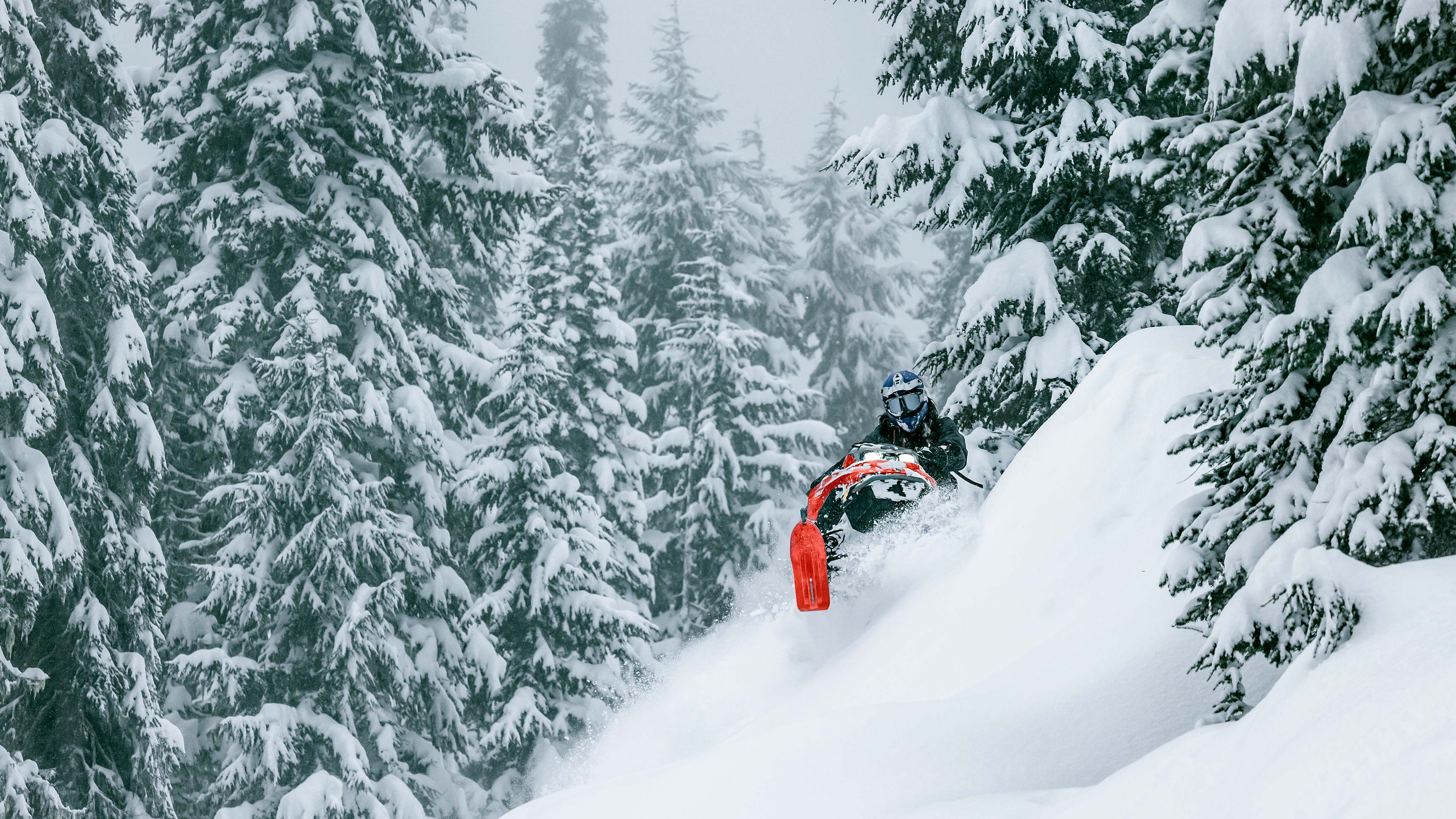 Jason Ribi kjører en Lynx snøscooter i fjellet