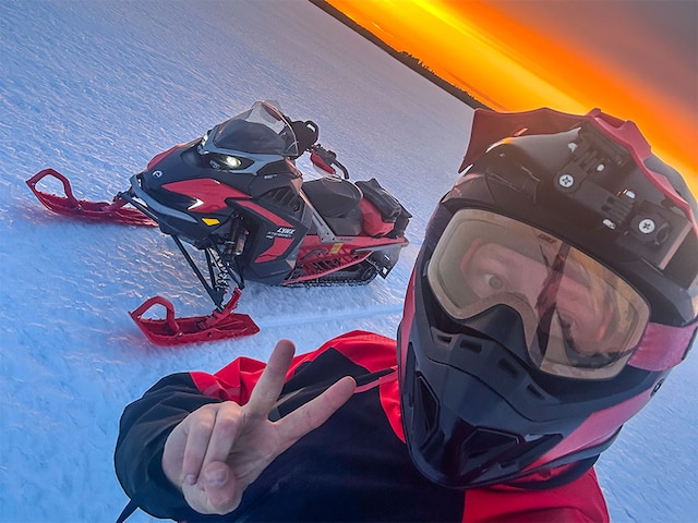 A man in a selfie next to Lynx Xterrain RE 850 E-TEC crossover snowmobile
