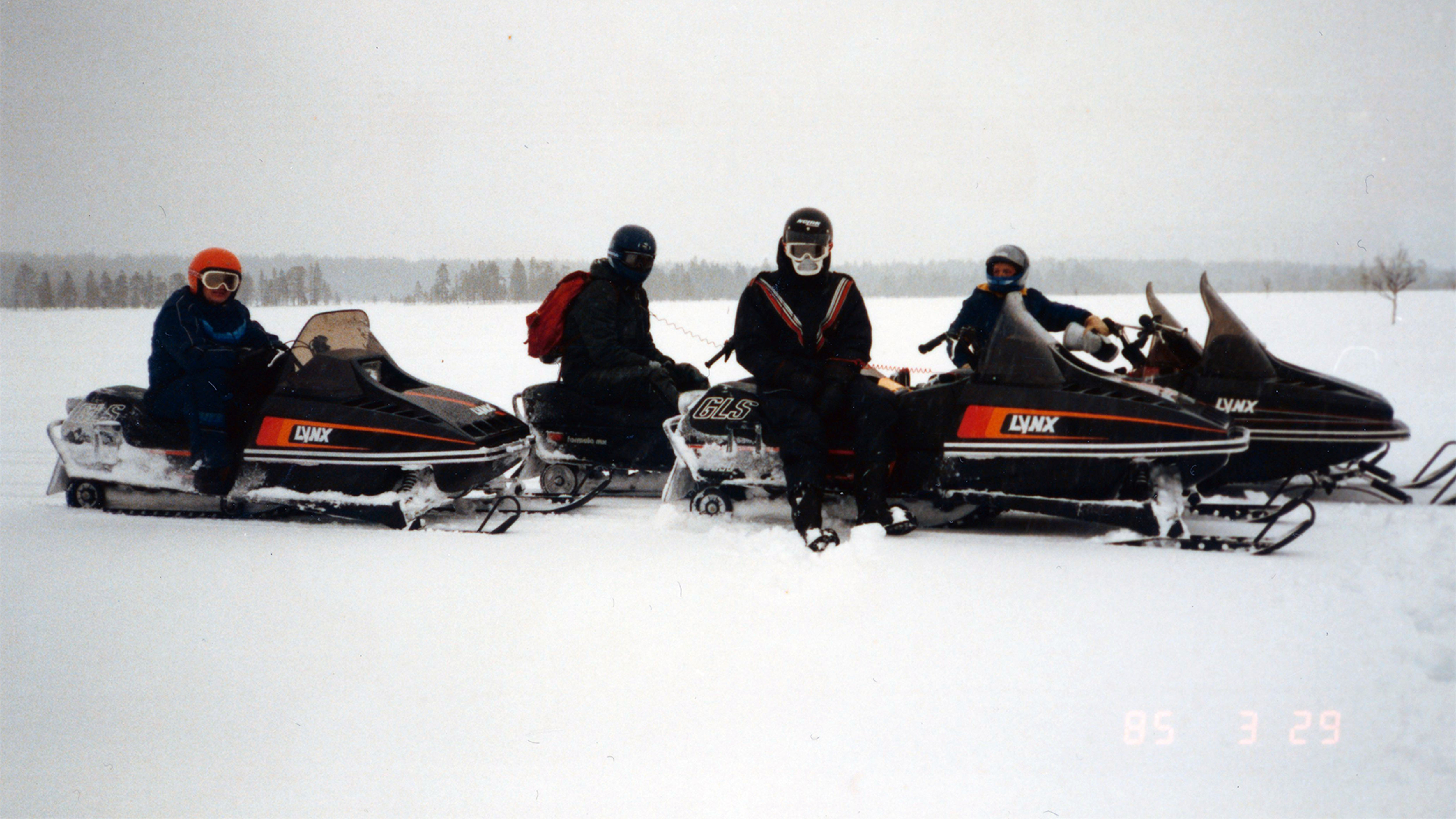 A group of riders taking a break on Lynx snowmobiles in wilderness