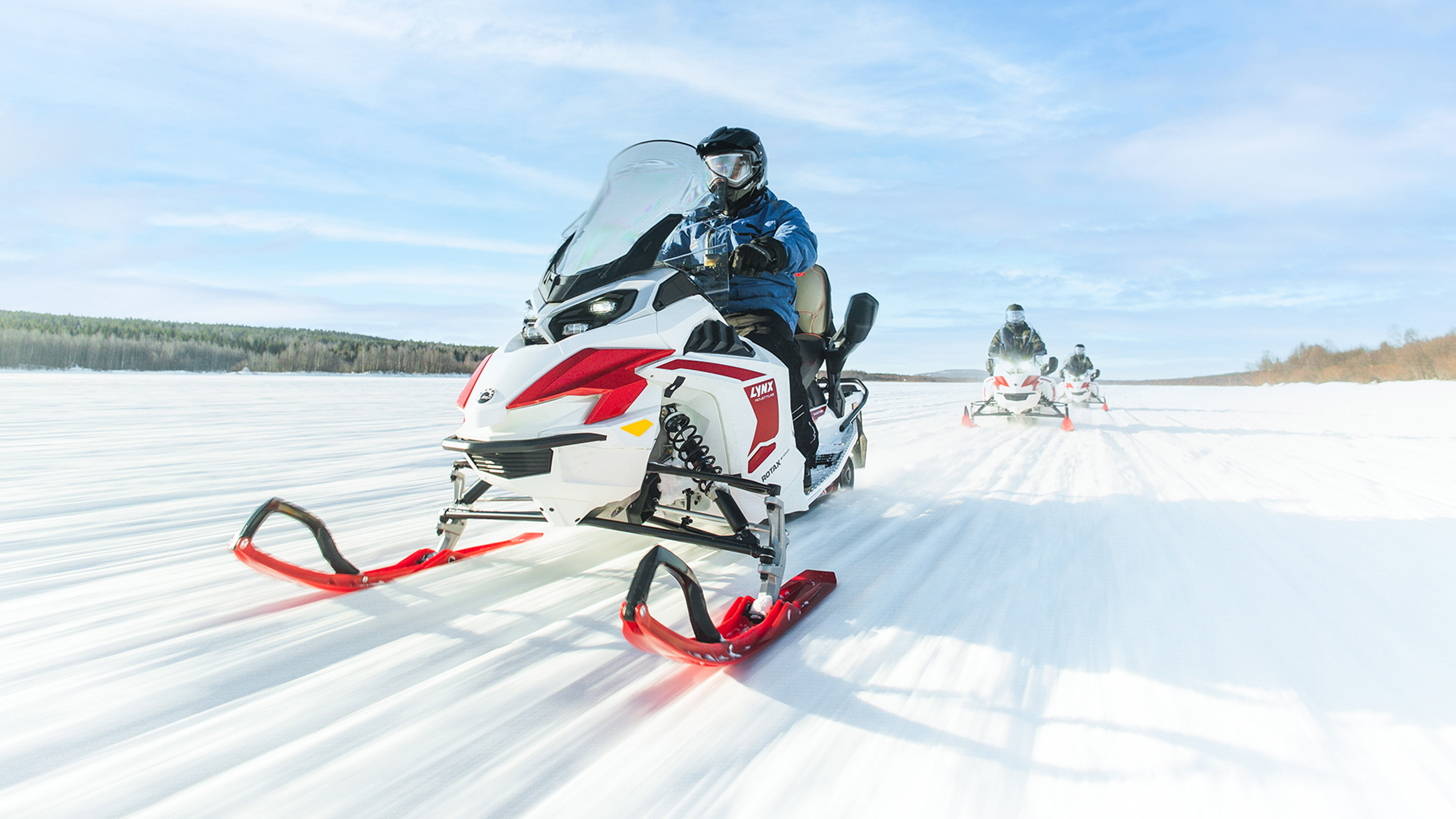 Tre Lynx Adventure Electric-snøscootere kjører i løypen.