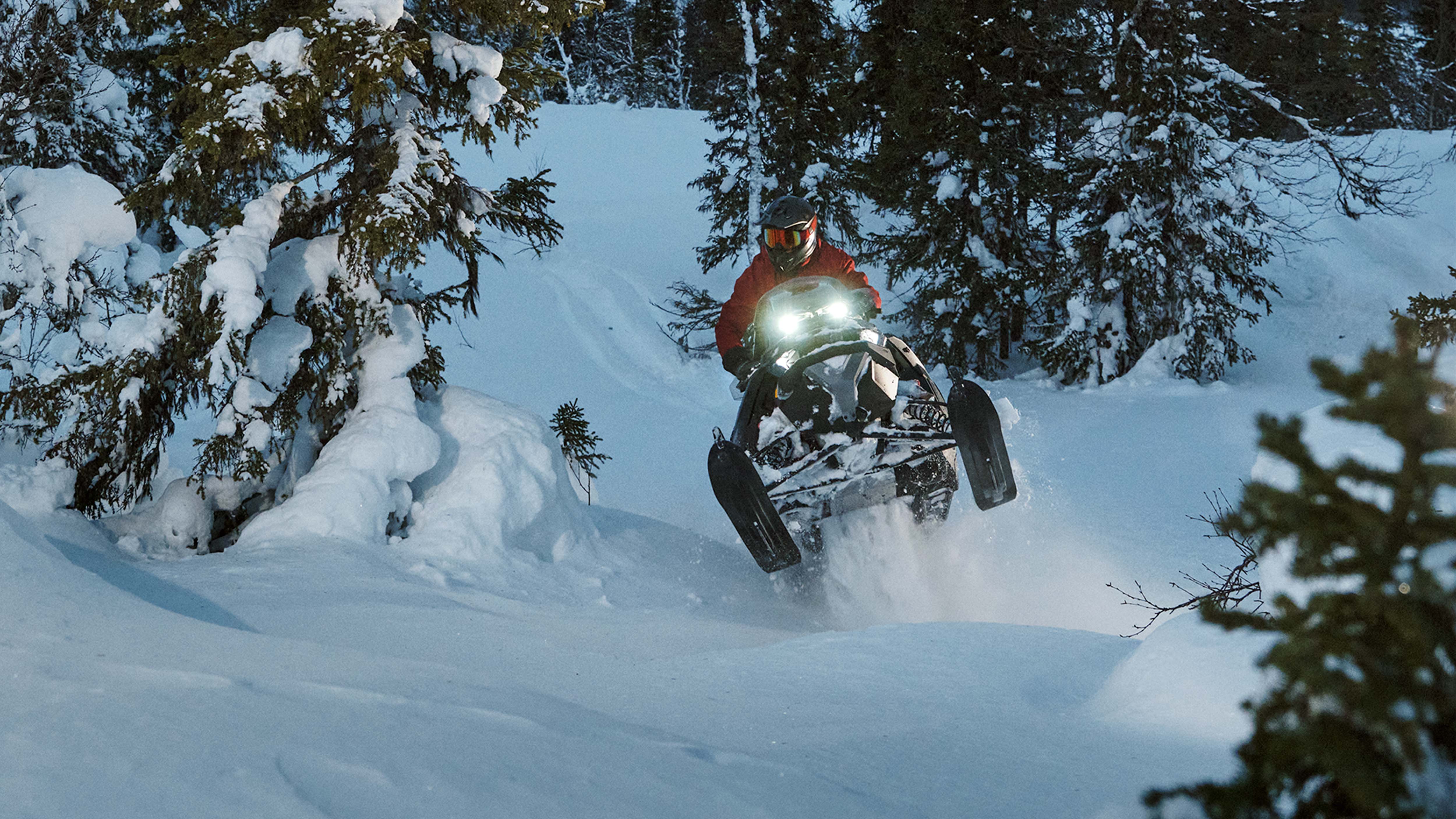 Motoneige Lynx Brutal RE 2025 montant une côte en forêt