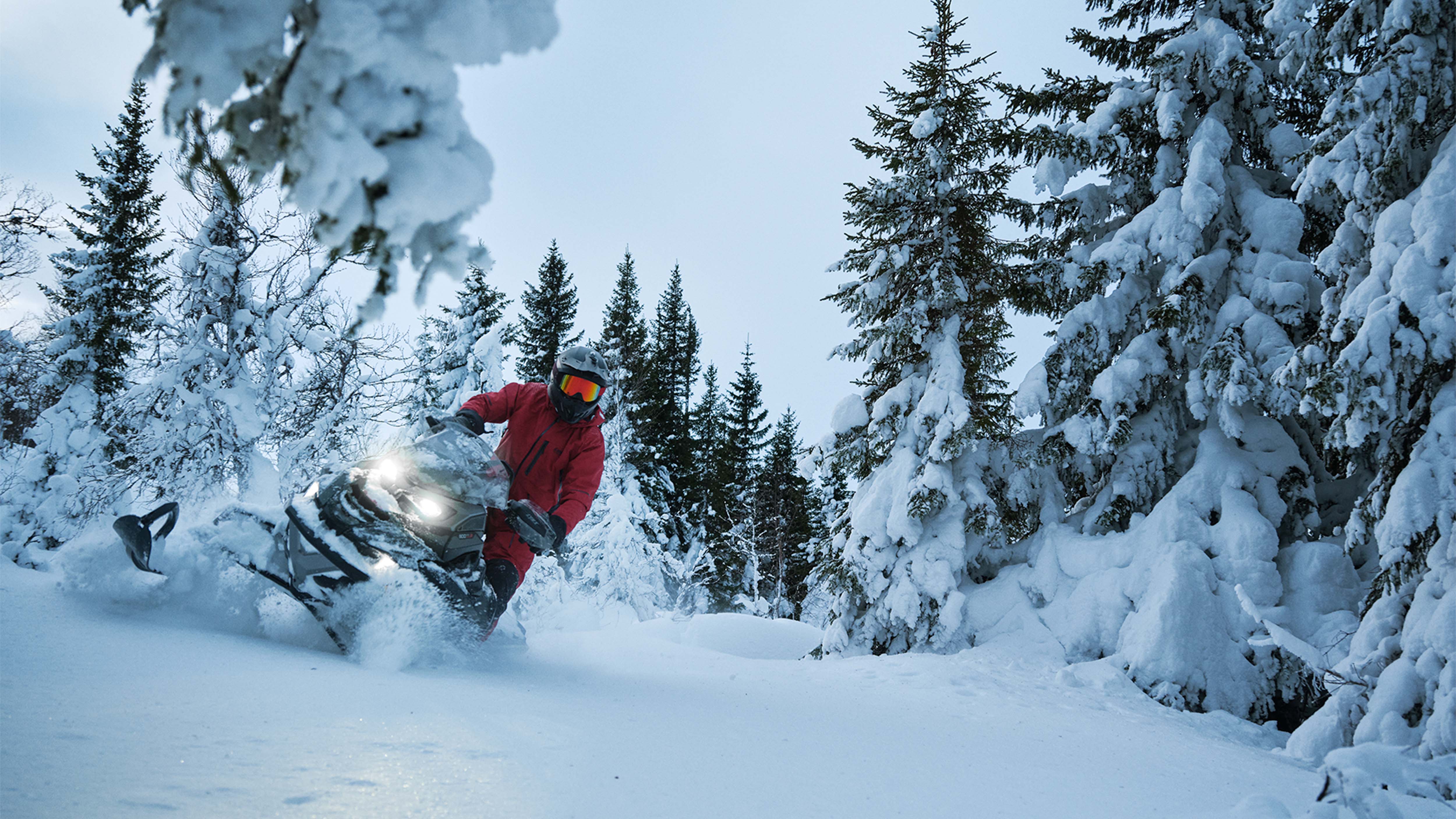 Lynx Brutal RE 2025 snøscooter som svinger i dyp snø i snørik skog