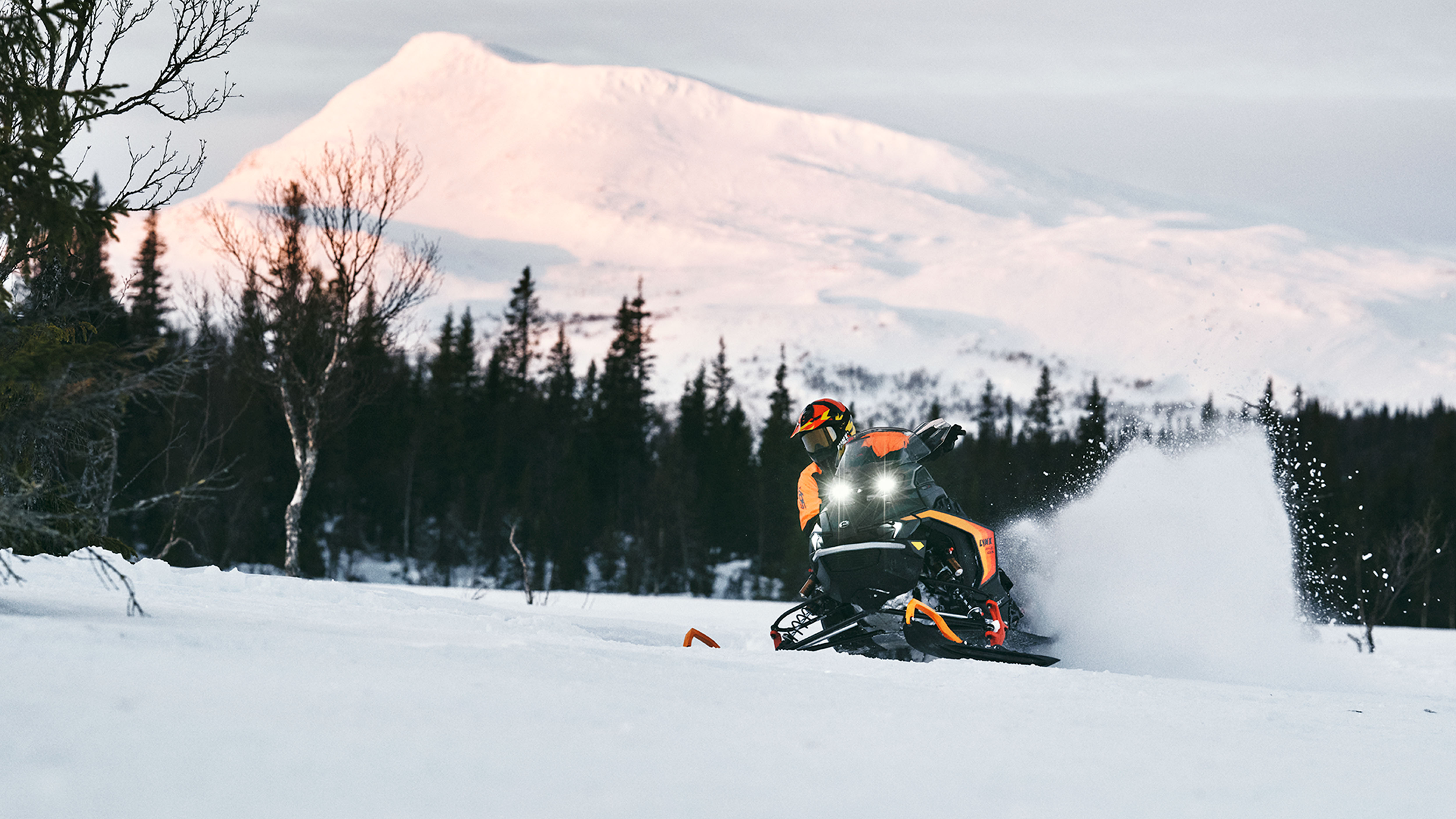 Lynx Rave GLS 2025 snöskoter i kurva på snöig led i soluppgången